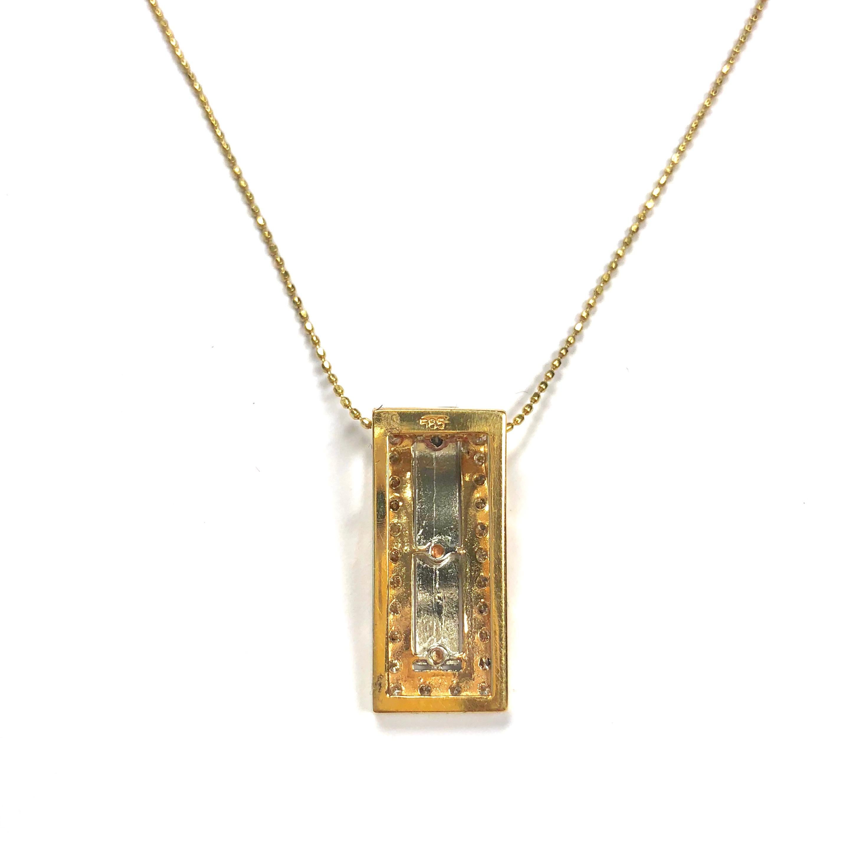 Crafted in 14K gold, the pendant features a white gold ribbon with roman numerals, set in a diamond set yellow gold bezel, supported by an eighteen inch length beaded chain. The folded ribbon style design with a large slide opening allows to put the