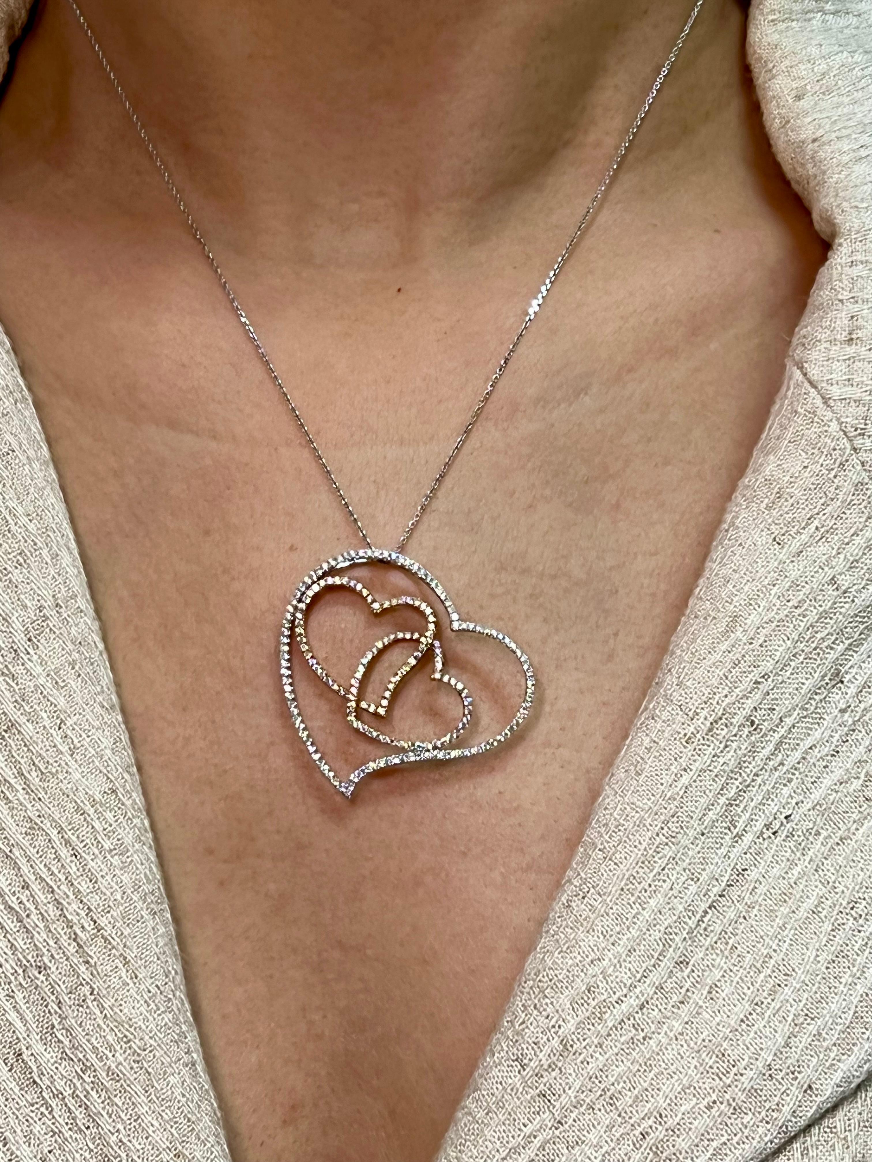 Please check out the HD video. This pendant has a 3D look with an excellent depth of field. It looks like 3 hearts floating. There are 190 diamonds totaling 1.08cts used in this rose and white gold setting. An 18k white gold chain will be included