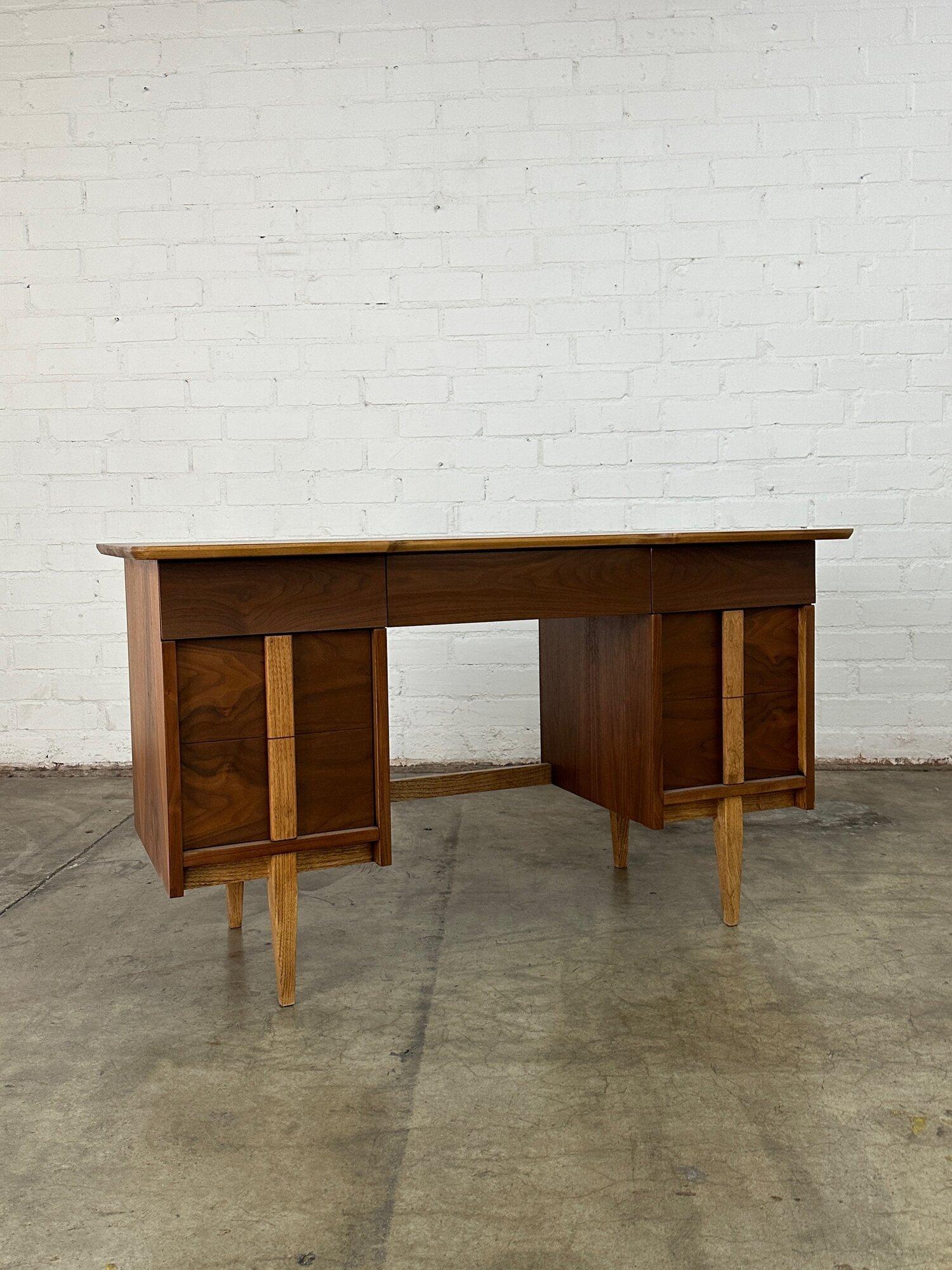W52.5 D23.25 H30 KNEE CLEARANCE 24 KNEE WIDTH 19.5

Fully restored walnut and oak desk circa 1960s. Item shows well with no major areas of wear. Item features exceptional grain throughout, sculoted handles, and is finished on all sides. Desk is