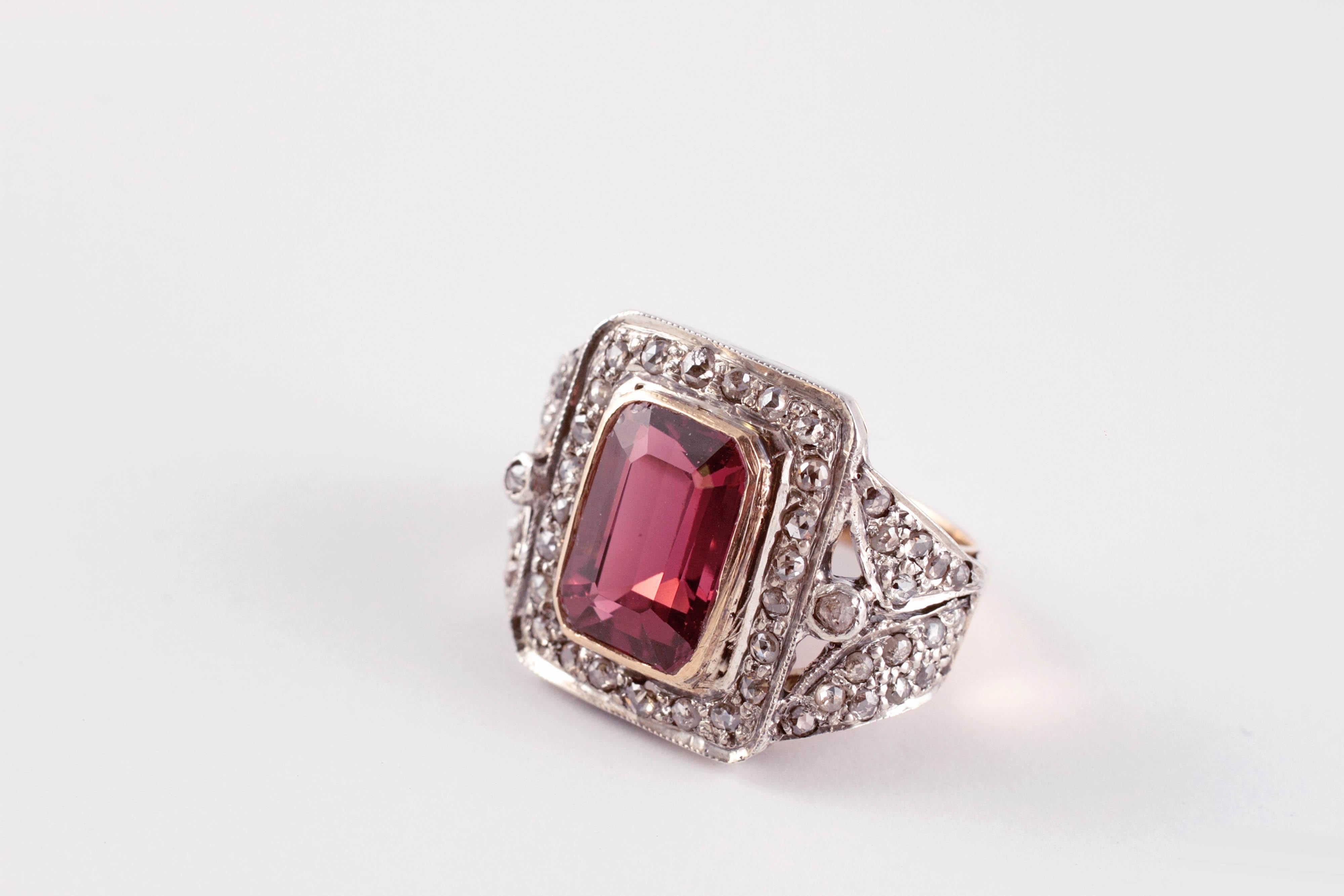 The pink in this tourmaline is just lovely!  Composed in two tone, 14 karat yellow gold, centered with a beautiful pink tourmaline and flanked by diamonds.  Size 5 1/2.