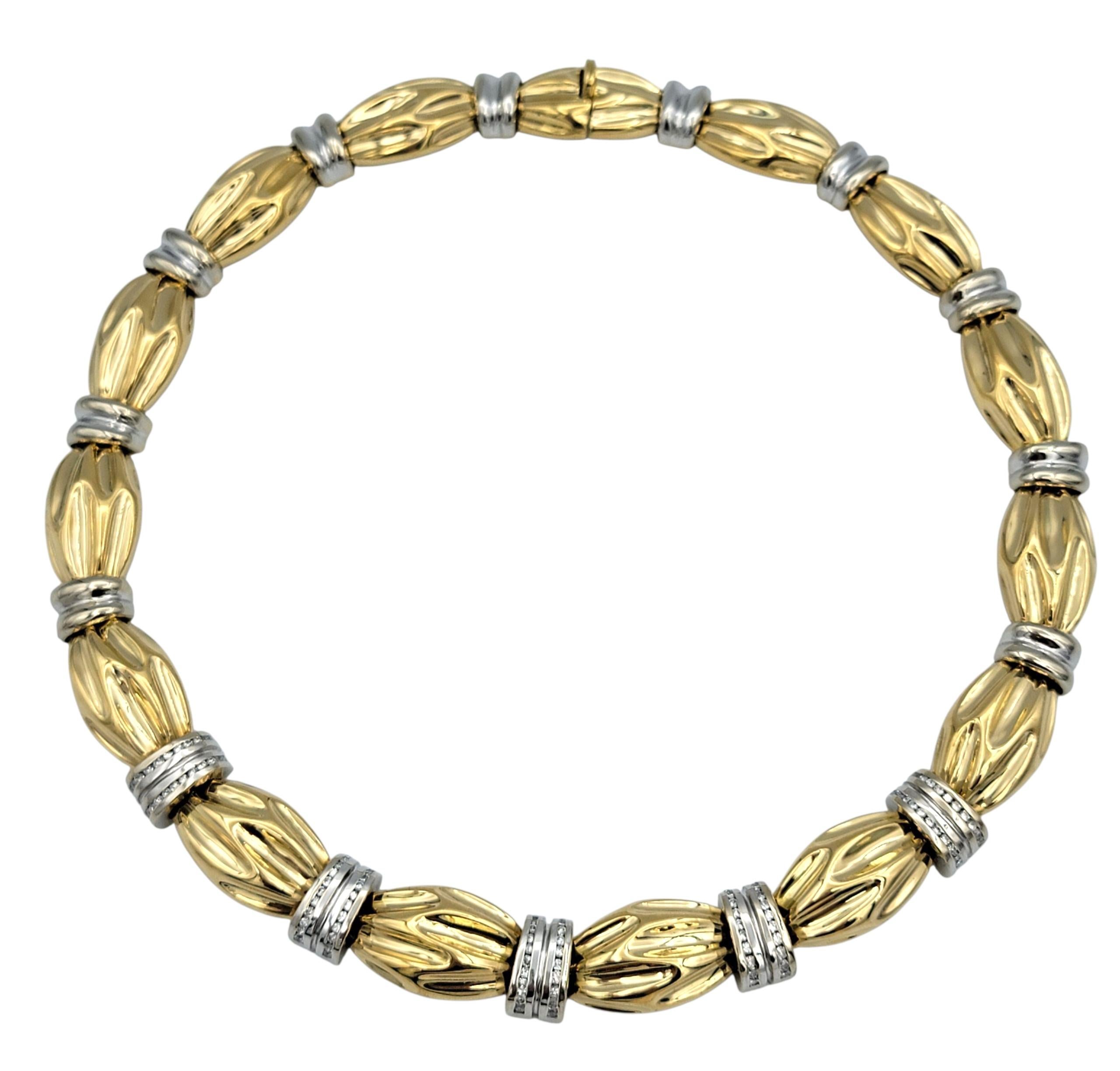 Elegant et richement détaillé, ce collier présente un design sculptural réalisé dans une luxueuse combinaison d'or blanc et jaune 18 carats. L'alternance des tons d'or crée un aspect dynamique et texturé, et les diamants ronds de taille brillante