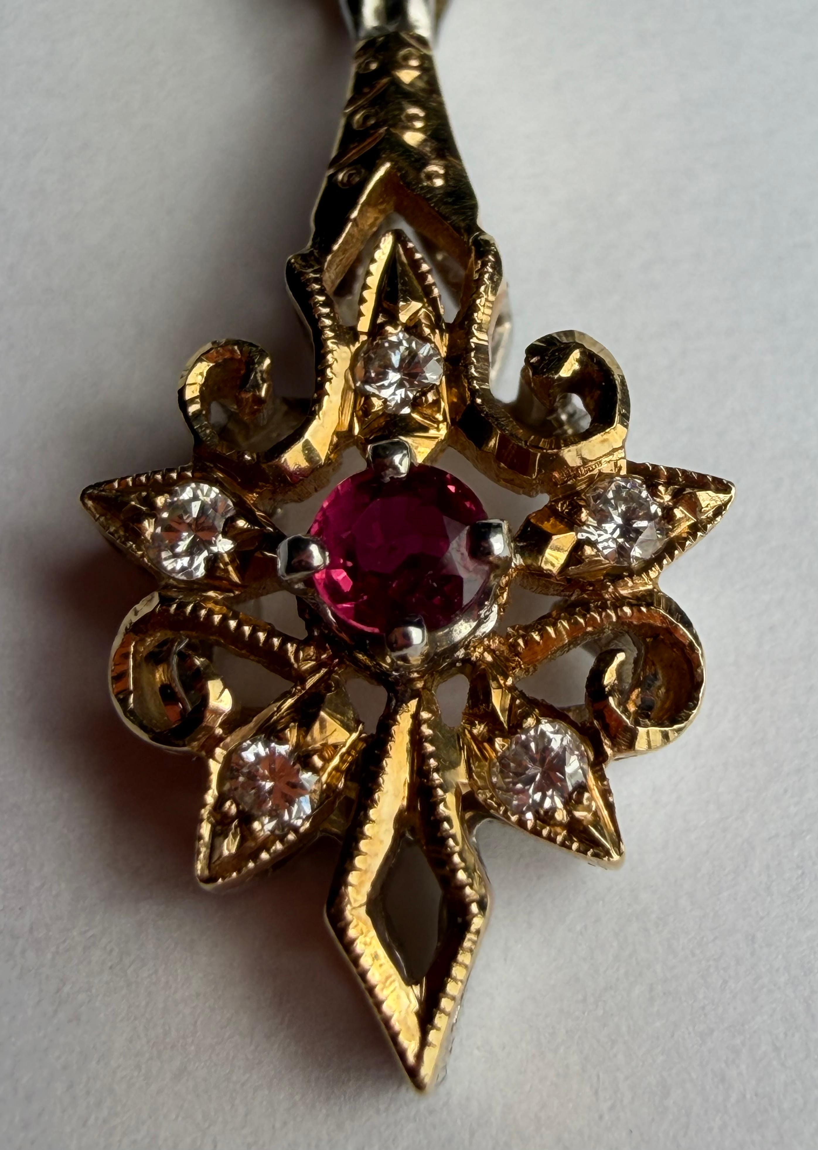 Un rubino rosso rotondo di 3 mm è al centro di questo pendente a raggiera ornato da cinque diamanti rotondi a taglio transitorio e impreziosito da una delicata satinatura e da un'intricata lavorazione del metallo. Incastonato in oro bianco e giallo