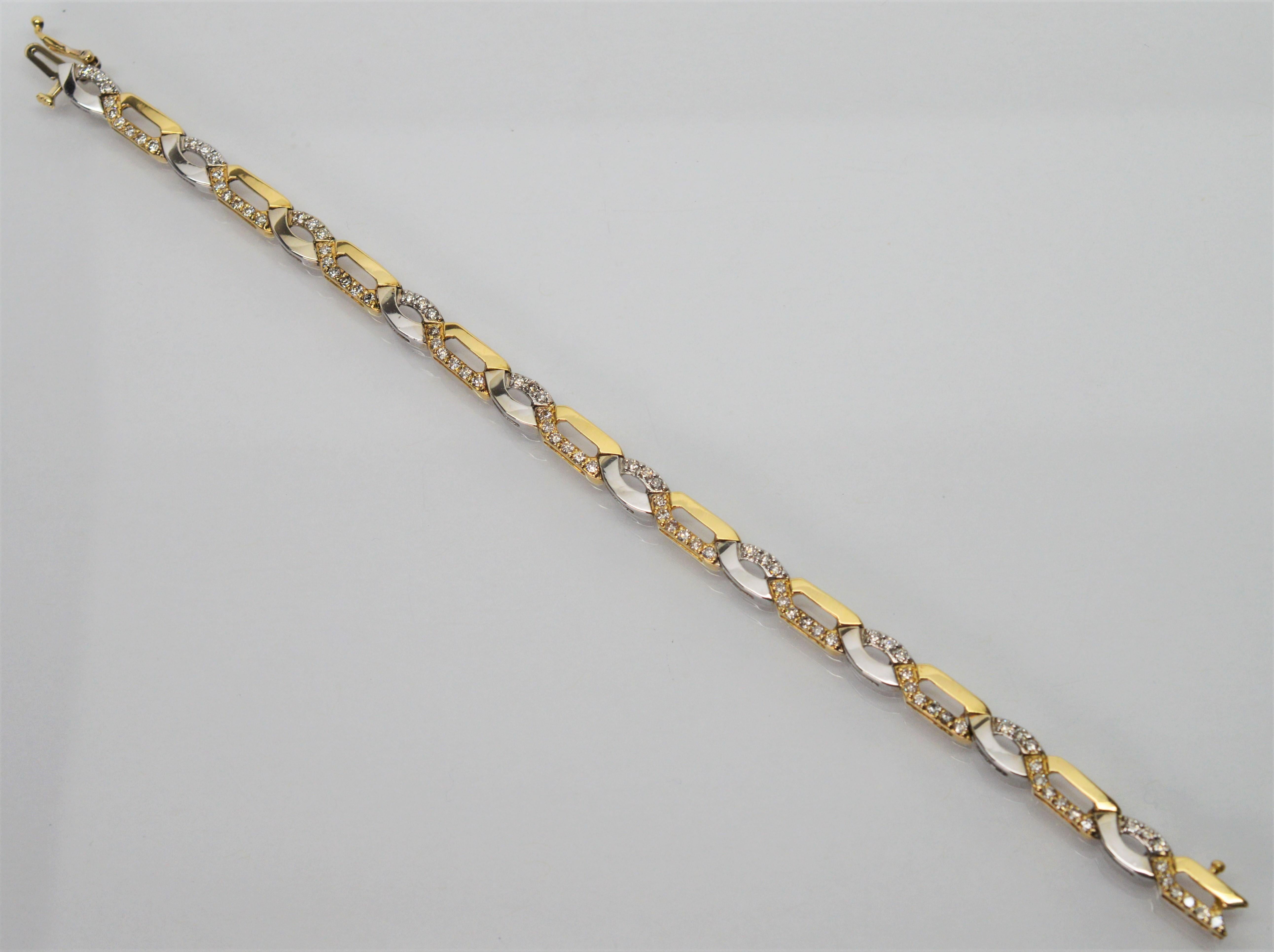 Slender links of intertwined fourteen karat yellow and white gold with diamond accents gently float over the wrist. This versatile and contemporary seven inch bracelet with links at just under 1/4 inch wide has a fresh, light look and will dress up