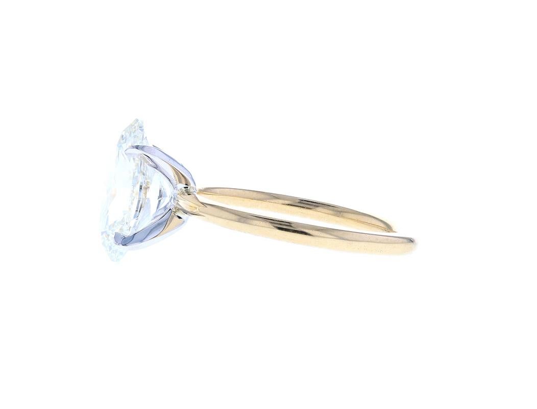 An elegant two tone yellow gold and white gold diamond engagement ring with an oval center. A head on shank setting with eagle claw prongs makes for a dainty effect. With a yellow gold shank and a white gold head, this beautiful engagement ring is a