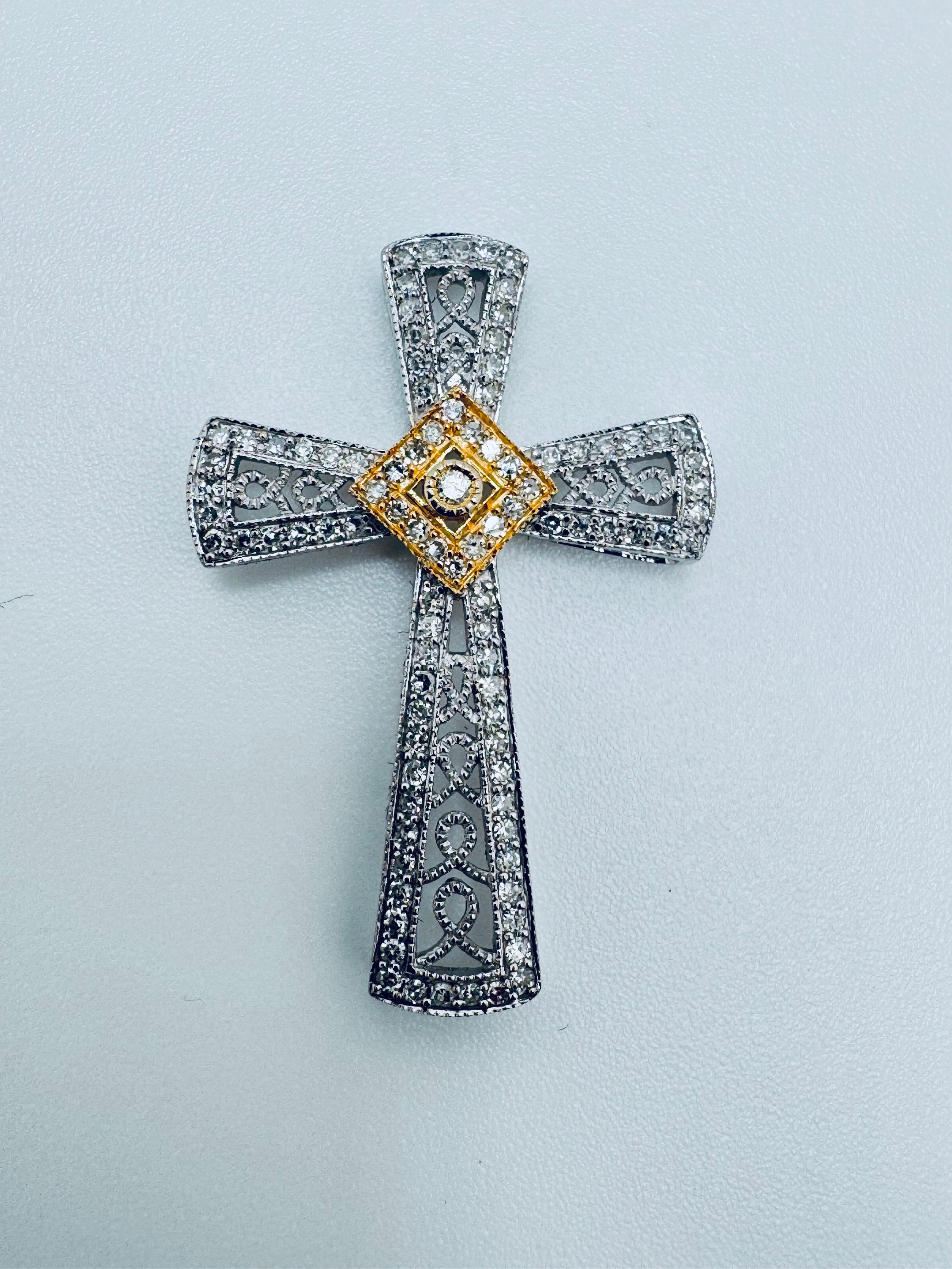 Questo ciondolo a forma di croce con diamante bicolore è un mix sorprendente di eleganza e maestria, realizzato principalmente in oro bianco 14 carati con sottili accenti di oro giallo per un tocco caldo e contrastante. Al centro si trova un singolo