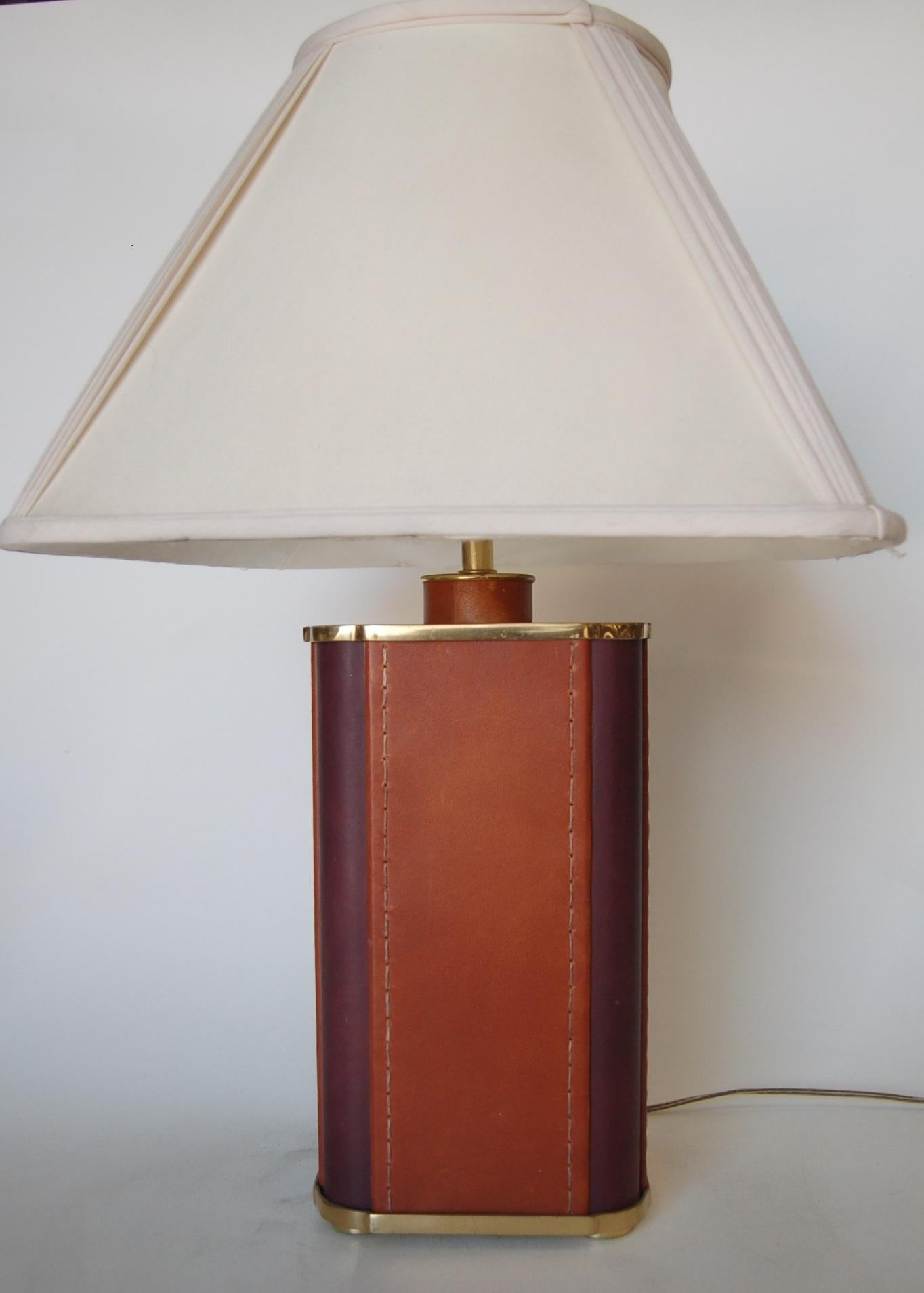 Large two-toned rust and wine leather square table lamp with gold trim. Measures: 8