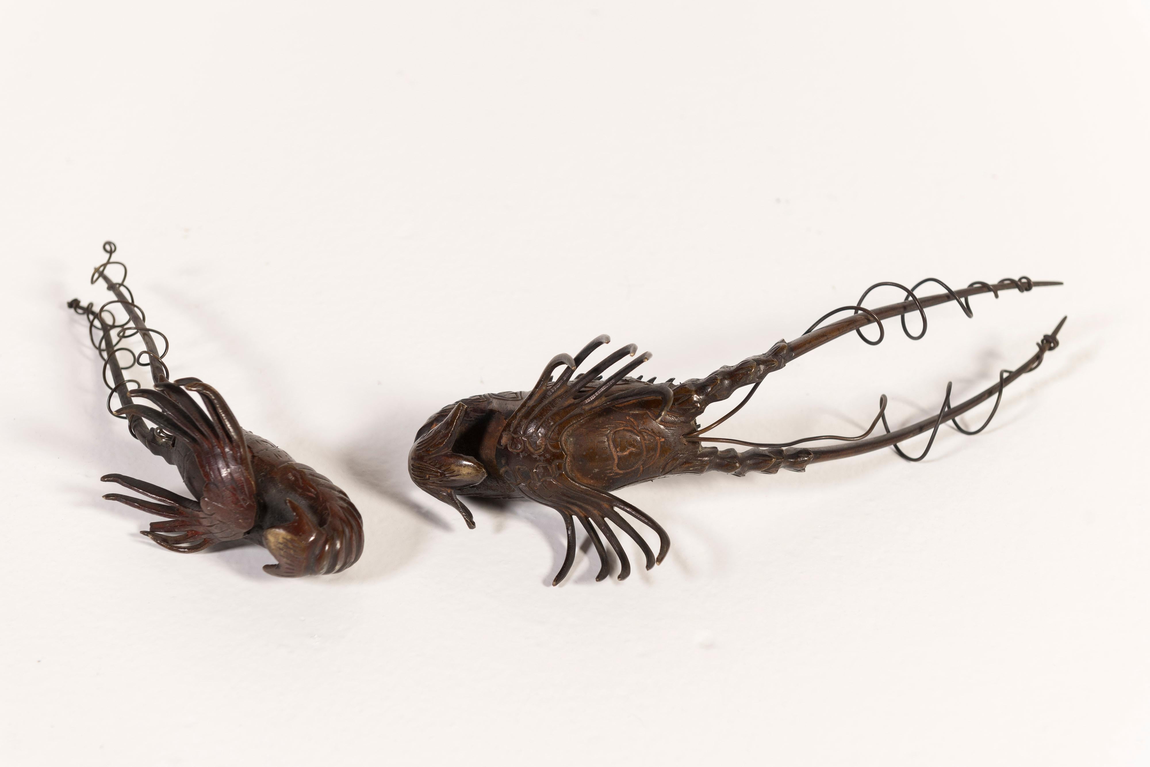 Bronze lobster sculptures, thought to be from 19th Century Japan, are sold as a pair and are unique in size and shape. Two Sizes: Large - 8