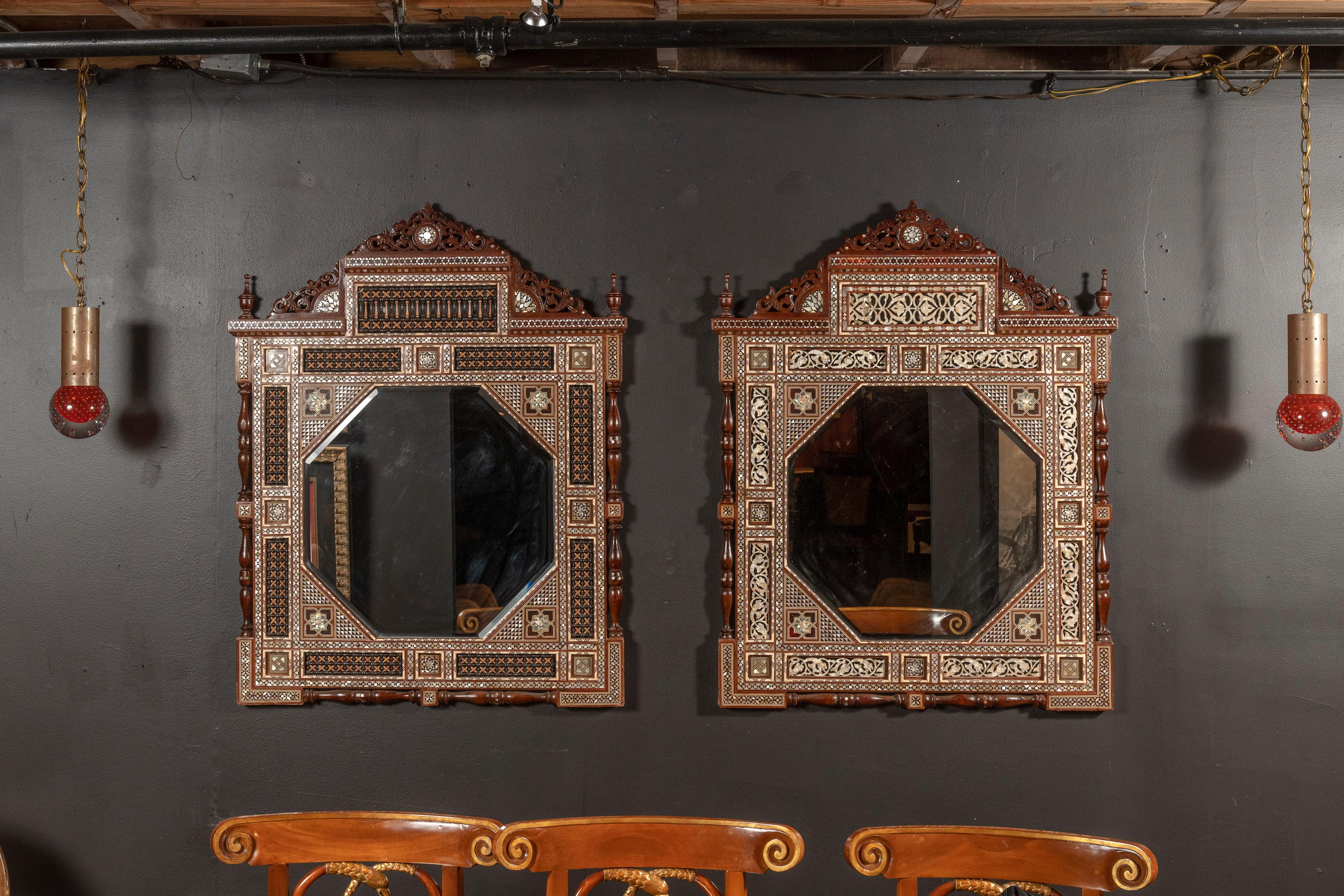 Two unique Syrian wall mirrors with very detailed mother of pearl inlay and intricate marquetry. The octagonal mirror is placed within the finely inlaid frame of floral and other geometric design, finished with a detailed crown. The mirrors are