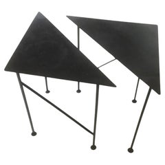 Dos singulares mesas triangulares de hierro ennegrecido hechas a mano para bebidas