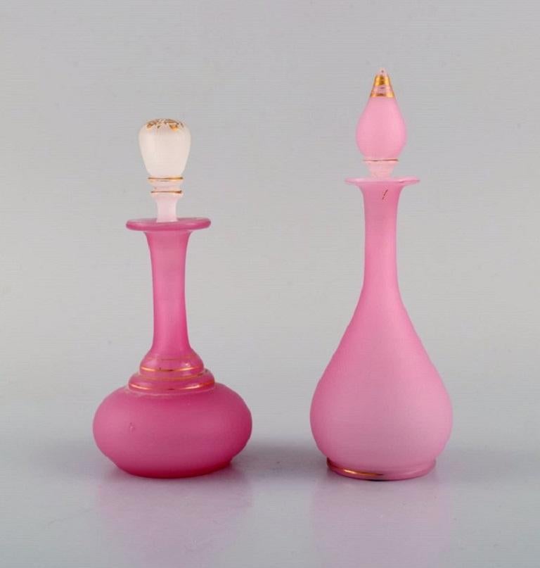 Deux vases et deux flacons en verre d'art soufflé à la bouche rose, décorés à la feuille d'or 24 carats. 
Italie, vers 1900.
Les plus grandes mesures : 16 x 6 cm.
En parfait état.