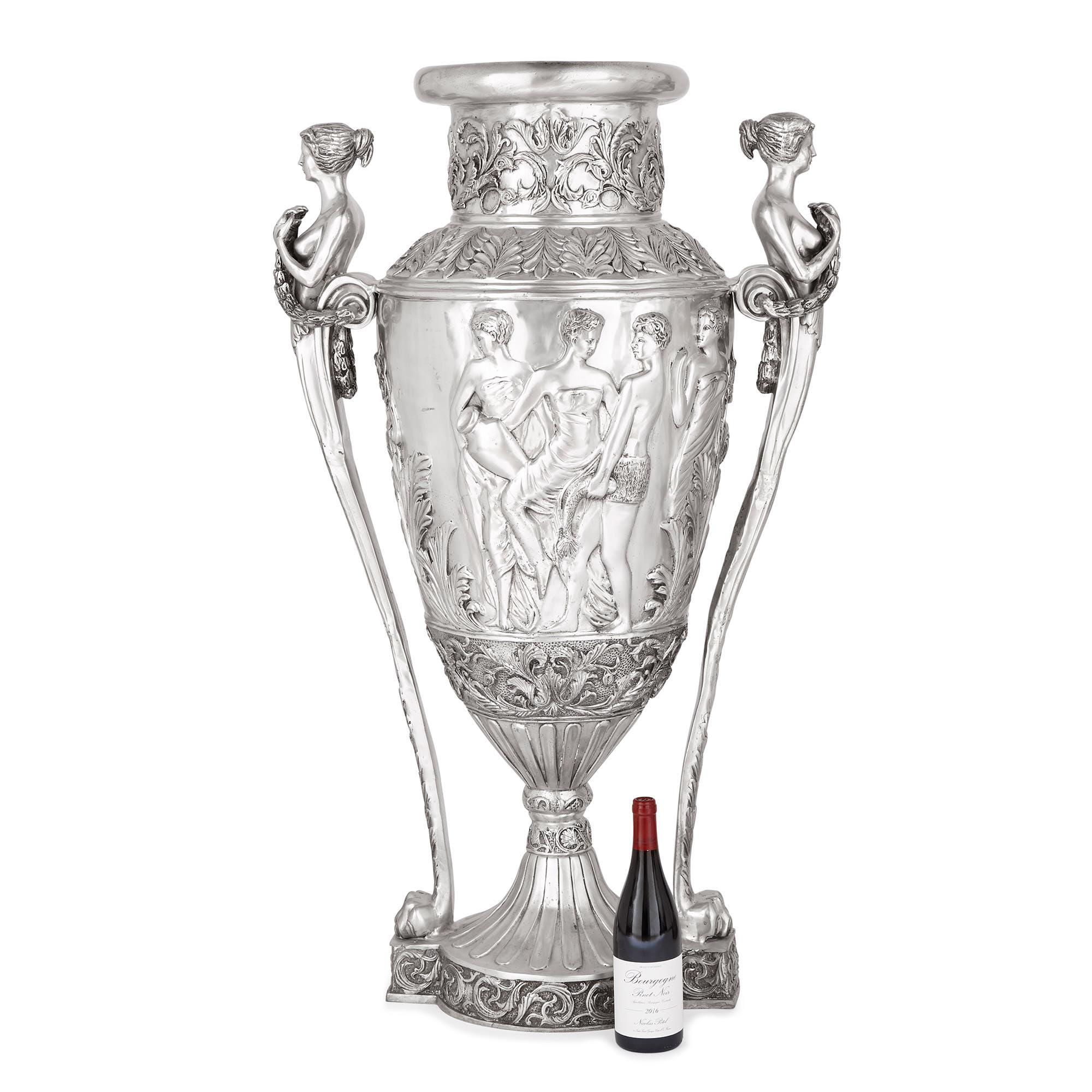 Standing 1.15 meters (45 inches) tall, these grand neoclassical style vases are designed to make an impact. Crafted from silvered bronze, the vases are truly magnificent works, which have been expertly cast and hammered, creating beautiful relief