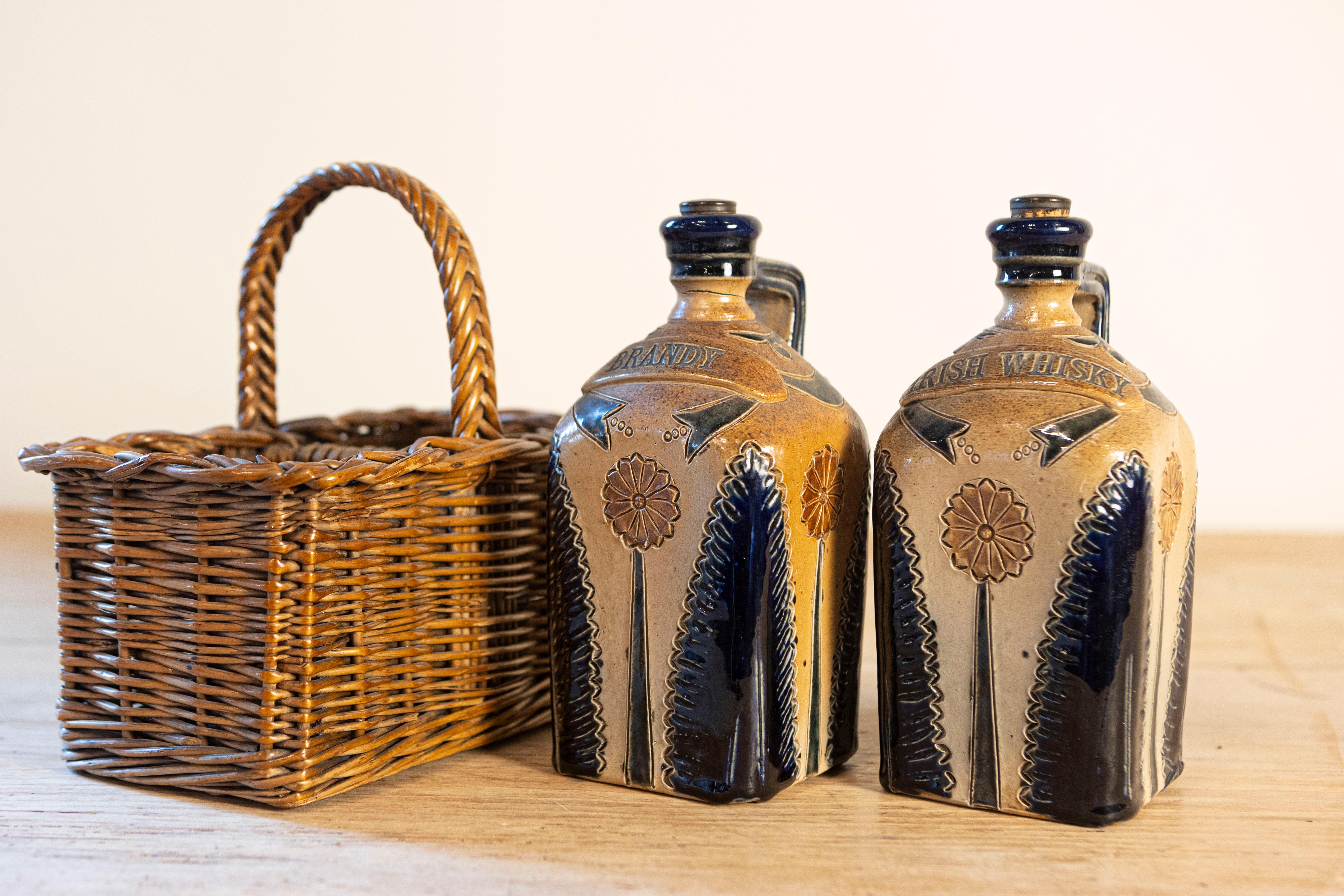 19th Century Two Victorian English Pottery Decanters in Tantalus-Inspired Wicker Basket For Sale