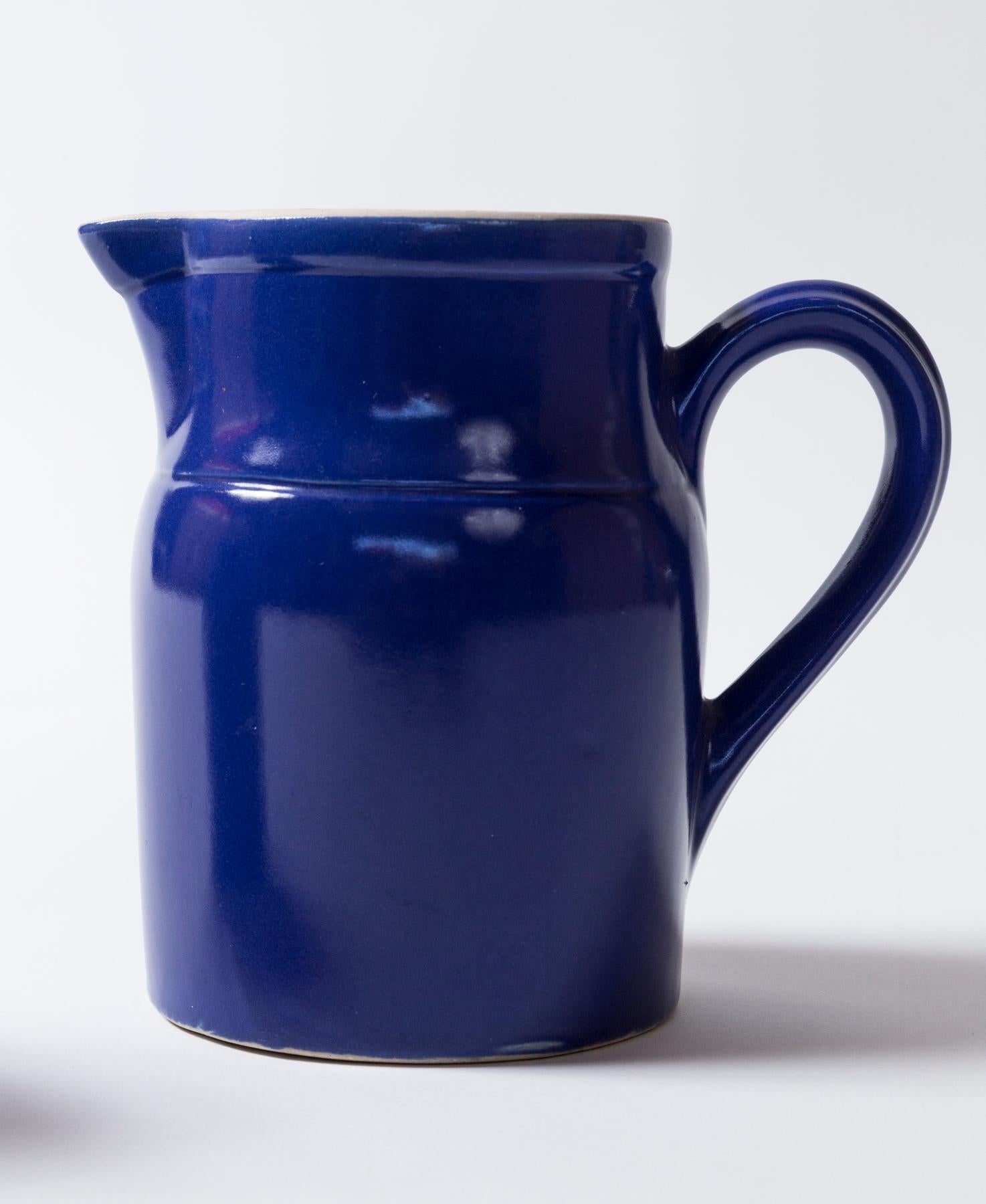 Two Vintage Ceramic Dairy Pitchers, Digoin, France, 1960's. Striking cobalt blue glaze with white glazed interior. Large: 7 inches high x 4-5/8 inches wide, 7-3/4 inches spout to handle. Small: 5-5/8 inches high x 3-3/8 inches wide, 6-1/4 inches