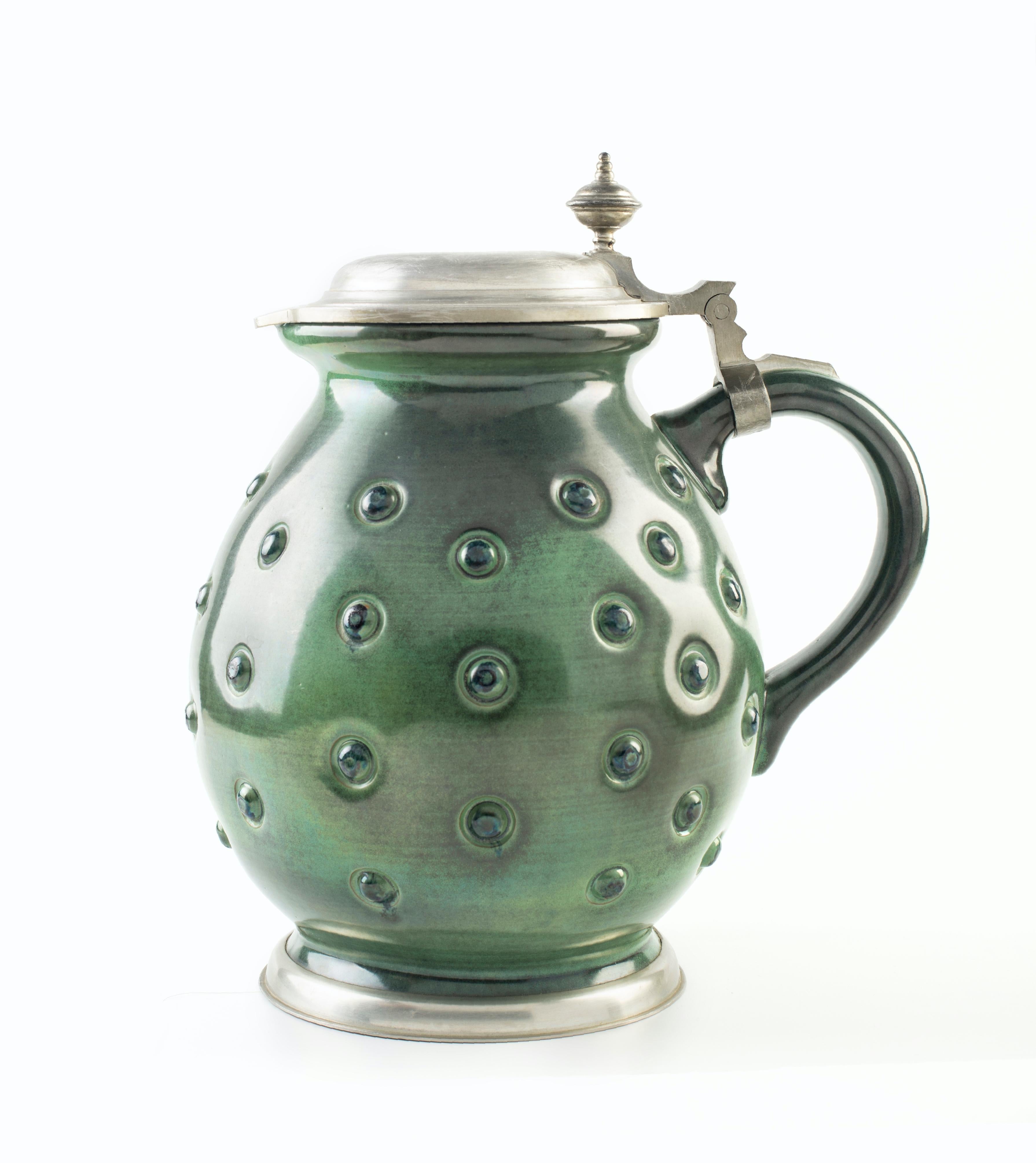 Two green pitchers by Eugen Wiedamann is an original decorative pair of objects realized between the 1950s and the 1970s.

Made in Germany and realized by Eugen Wiedamann, Regensburg.

The pair is composed by different materials: metal, colored