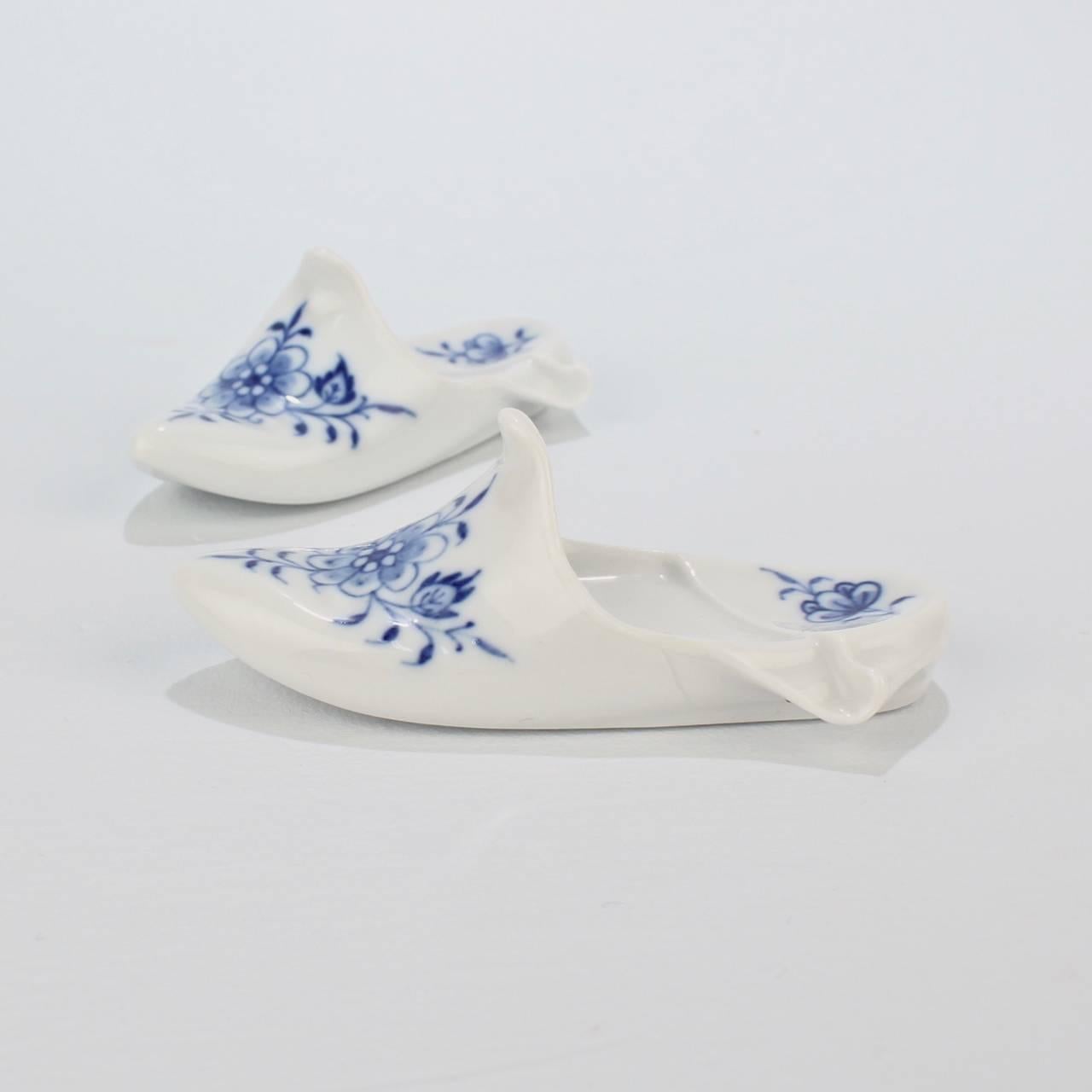A group of two small, vintage Meissen blue onion (or Zwiebelmuster) pattern figural paperweights.

These paperweights are an iconic Meissen form in the shape of a traditional slipper (Pantoffel) or shoe.

The base bears a blue underglaze crossed