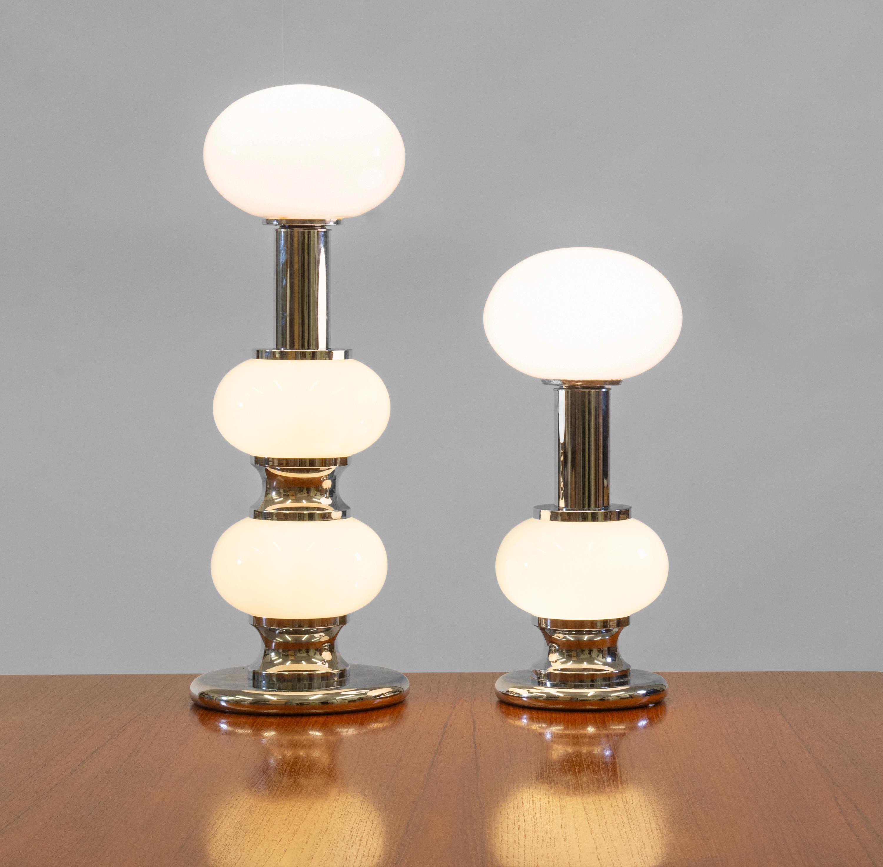 Two vintage chrome plated & opaque white glass Modernist table lamps, designed and manufactured by Sölken Leuchten in Germany during the 1970s. Part label to one.

Delivery included to the mainland UK.

The lamps have later opaque glass shades with