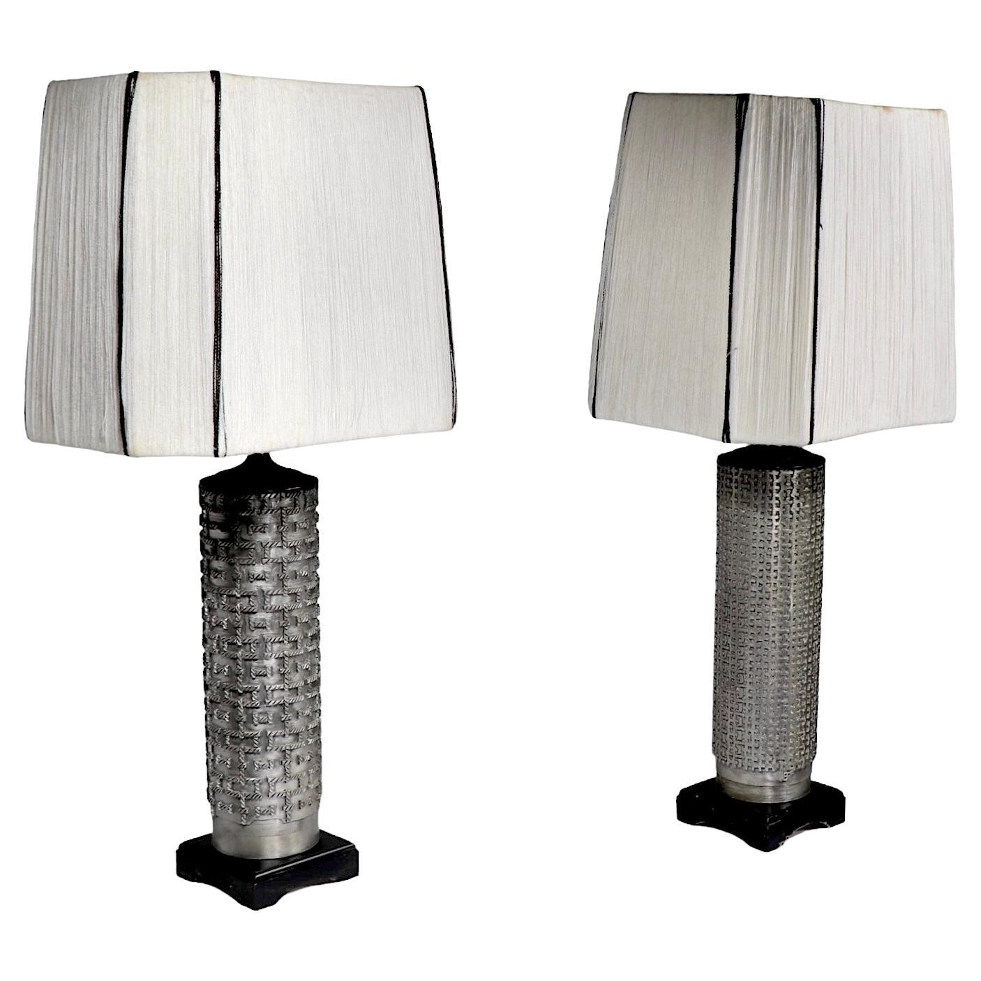 Chic table lamp(s) constructed of vintage metal wallpaper rollers, later mounted as lamps. The lamps feature oriental style bases, constructed of wood, in black paint finish, both include the period hand woven shades, in white and black yarn. The
