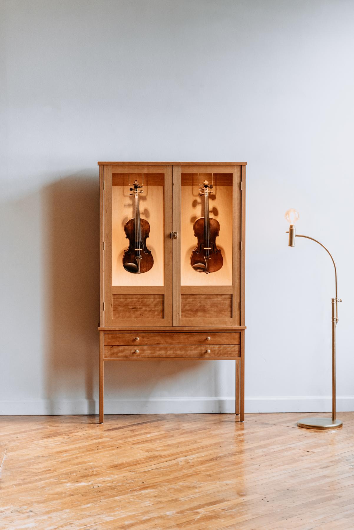 The Violin Habitat is a freestanding humidity-controlled cabinet for elegantly displaying and protecting your violins. This Habitat will comfortably store & display two violins behind double doors, adorned with brass hardware accents.

Completely
