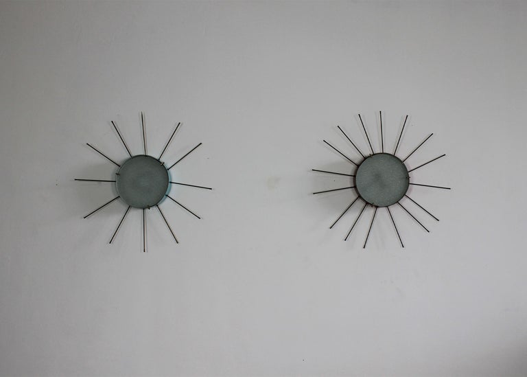 Two appliques or wall lamps (they can also be used as ceiling lamps as well) with structure in lacquered metal (one is in a light blue shade and one is in a brilliant red shade) stamped glass and details and hand-made spikes in brass. 

These