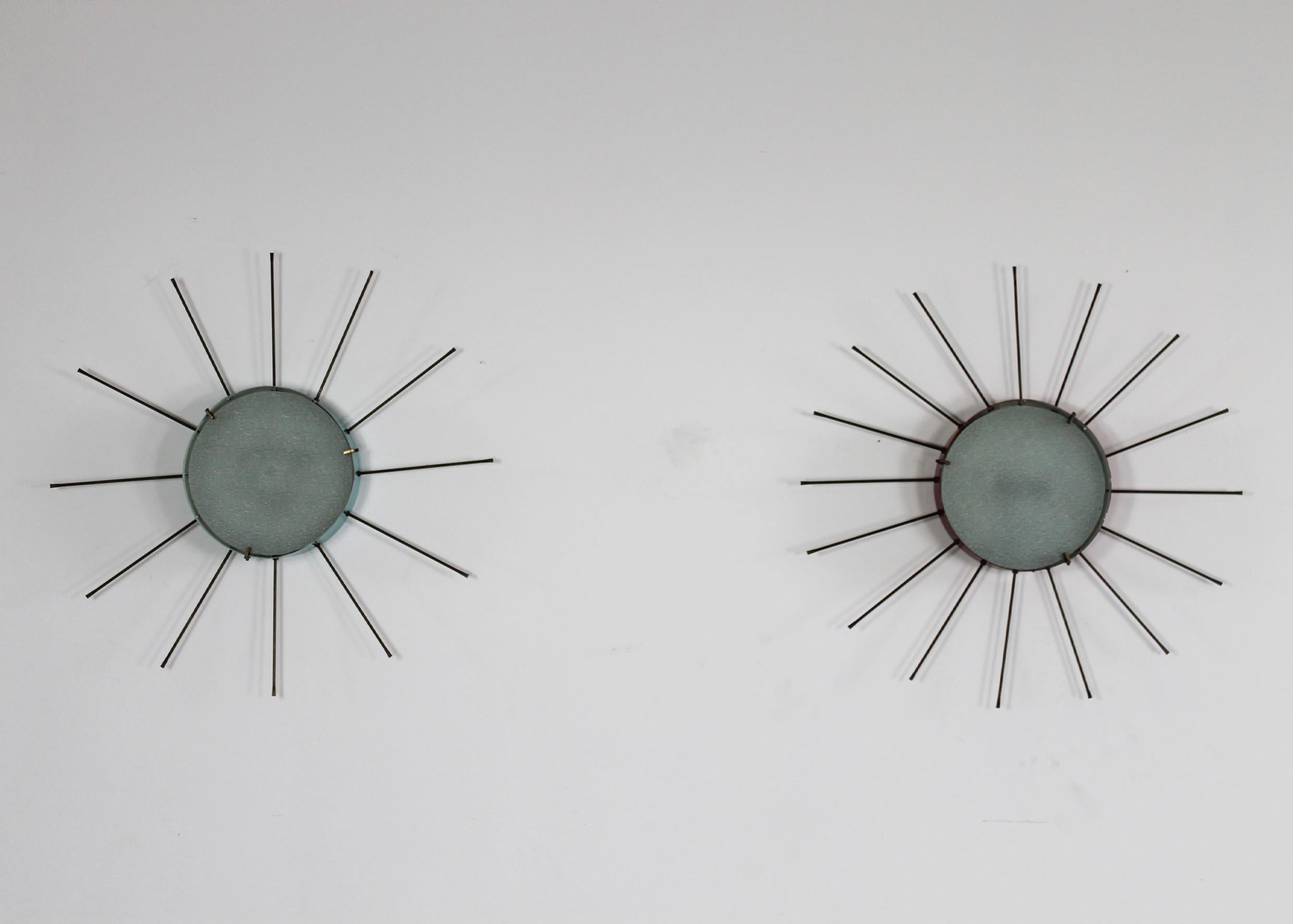 Set of two wall lamps (they can also be used as ceiling lamps as well) with structure in lacquered metal (one is in a light blue shade and one is in a brilliant red shade) stamped glass and details and hand-made spikes in brass. 

These lamps were