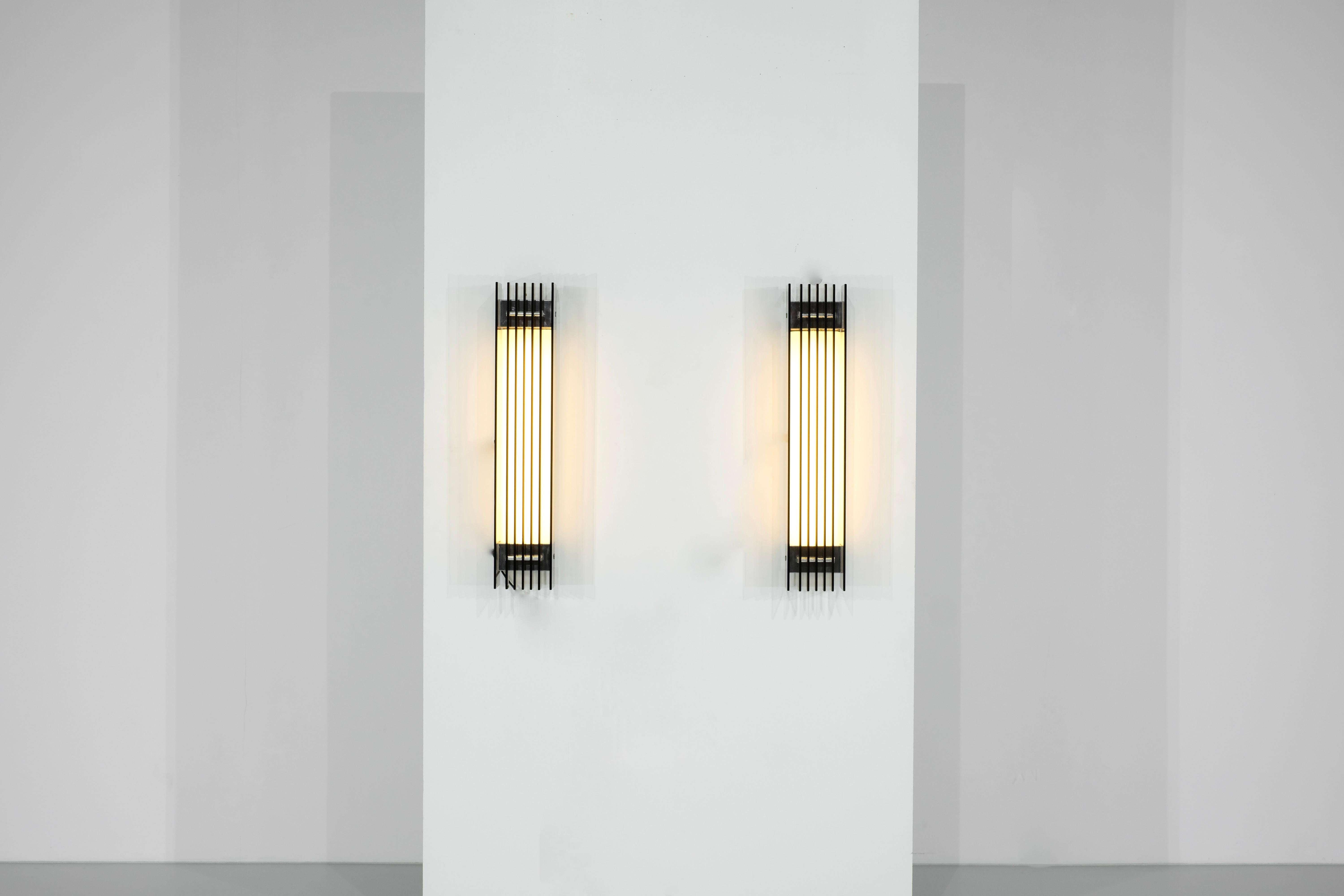 Pair of large Wall Lights composed of several rectangular slats of smoked glass, illuminated by a diffused light covered by Plexiglas.
Label FAB, Italy 1970s.

 

 

Producer - FAB.

Production period - 1970s.

Measures - Width 15 cm x Depth 13,5 cm