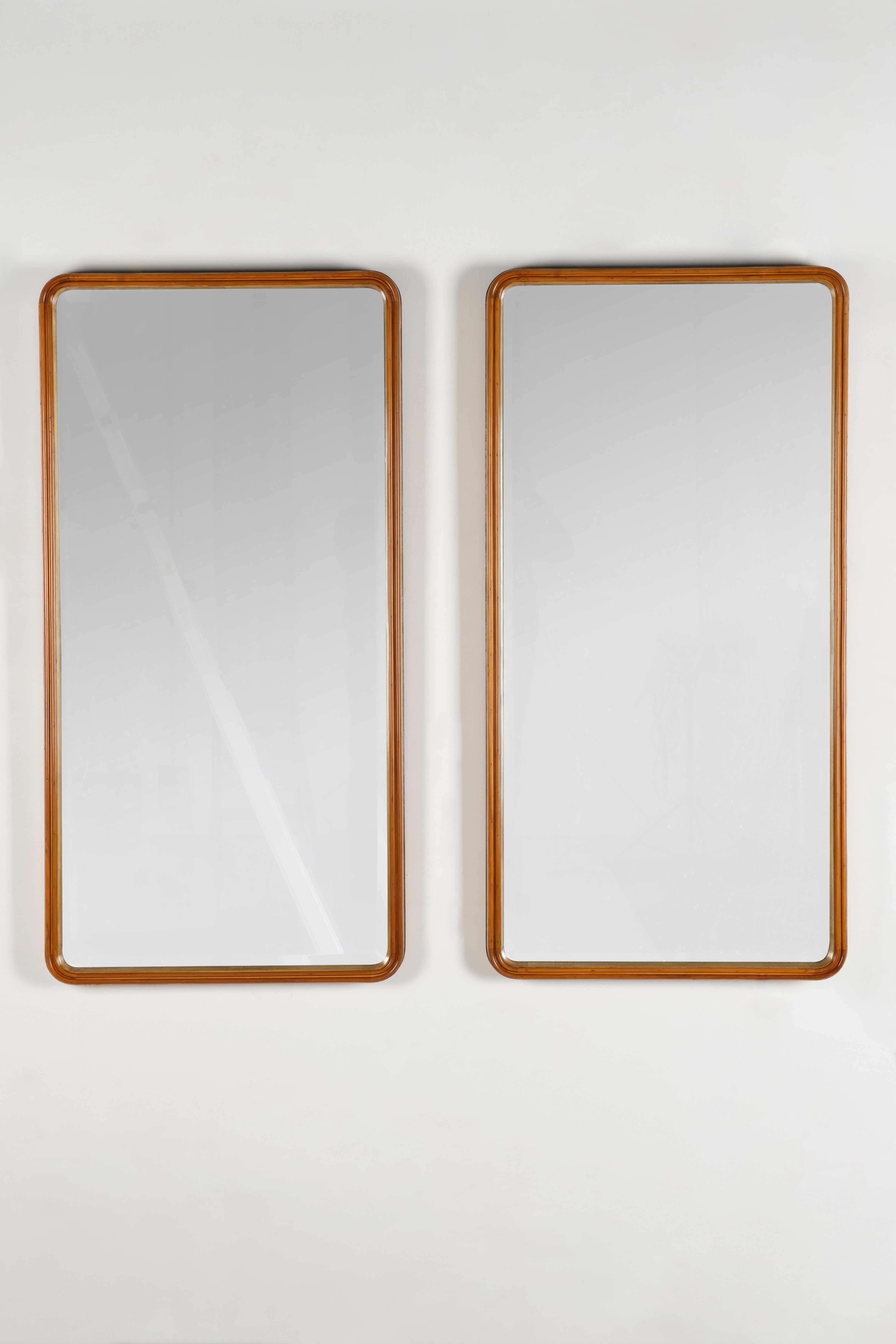 Pair of modernist wall mirrors with wooden construre and covered by lacquered parchment, creating color variations.
    