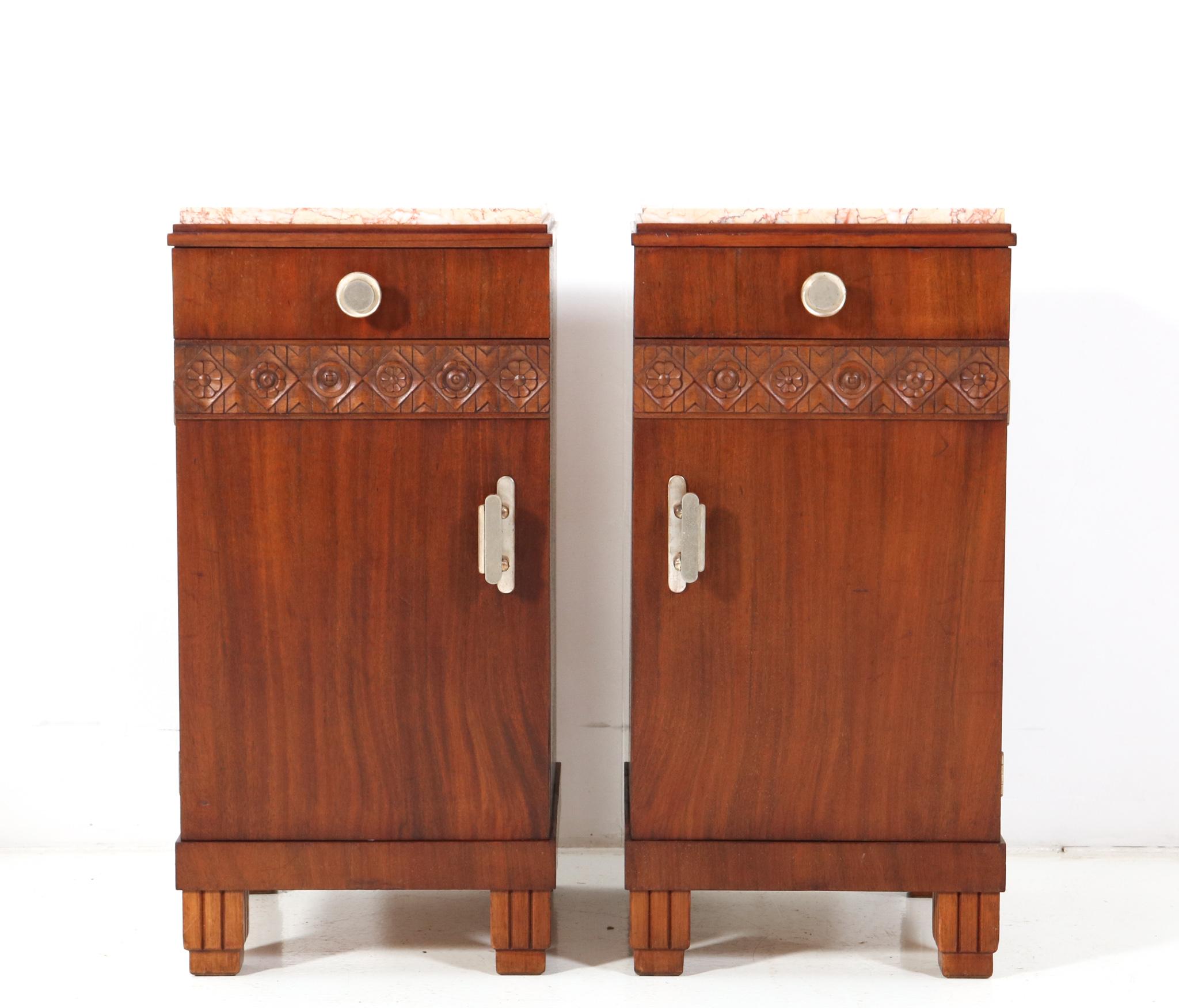 Stunning pair of Art Deco nightstands or bedside tables.
Striking French design from the 1930s.
Solid walnut and original walnut veneer base.
The doors and drawers have the original handles and knobs.
Original multi-colored marble tops.
This