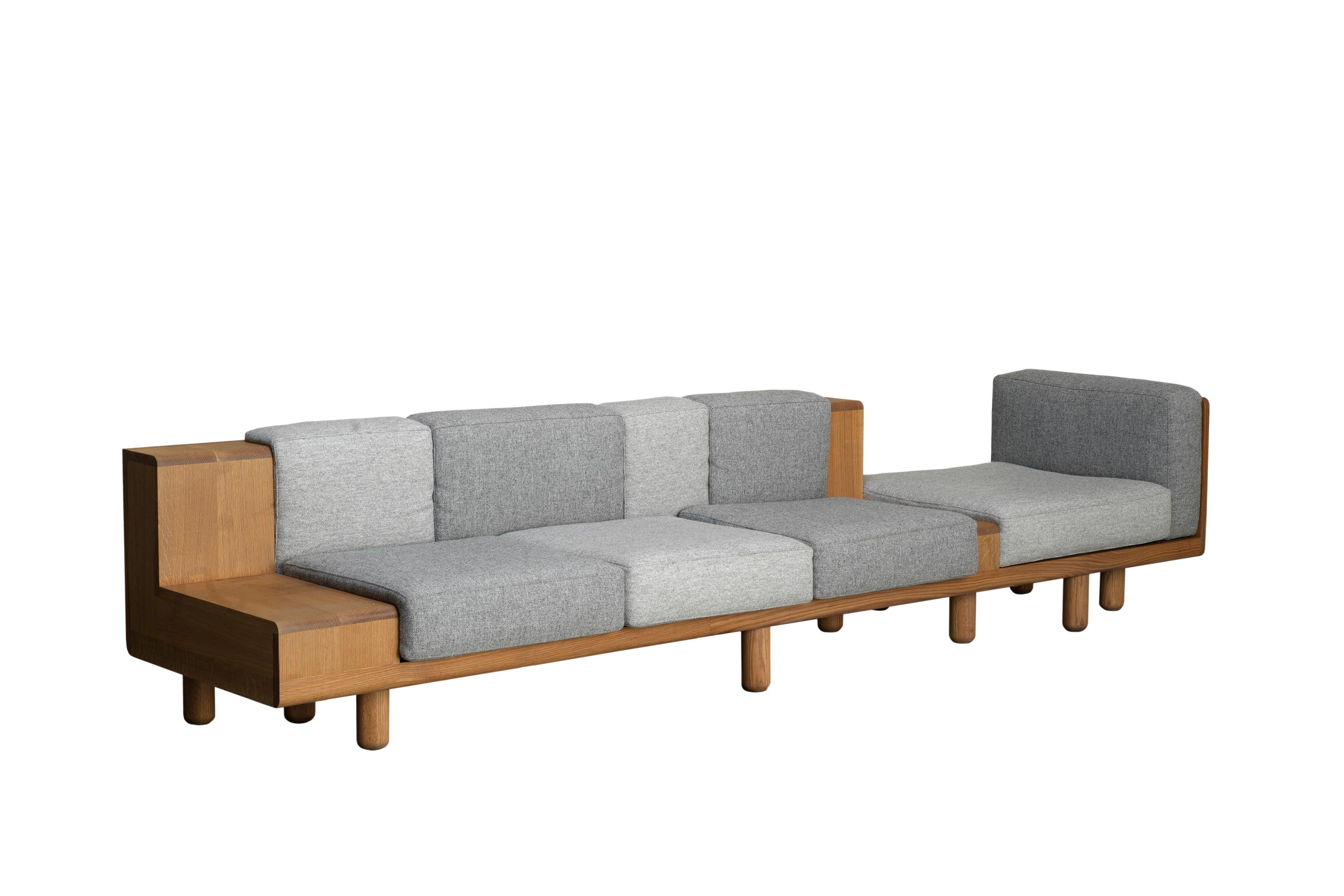 A stretched sofa for large spaces with generous seating for 4. The visually extruded form alternates between solid and soft accommodating different ways of sitting with places to rest your drink or stack some reading. 


