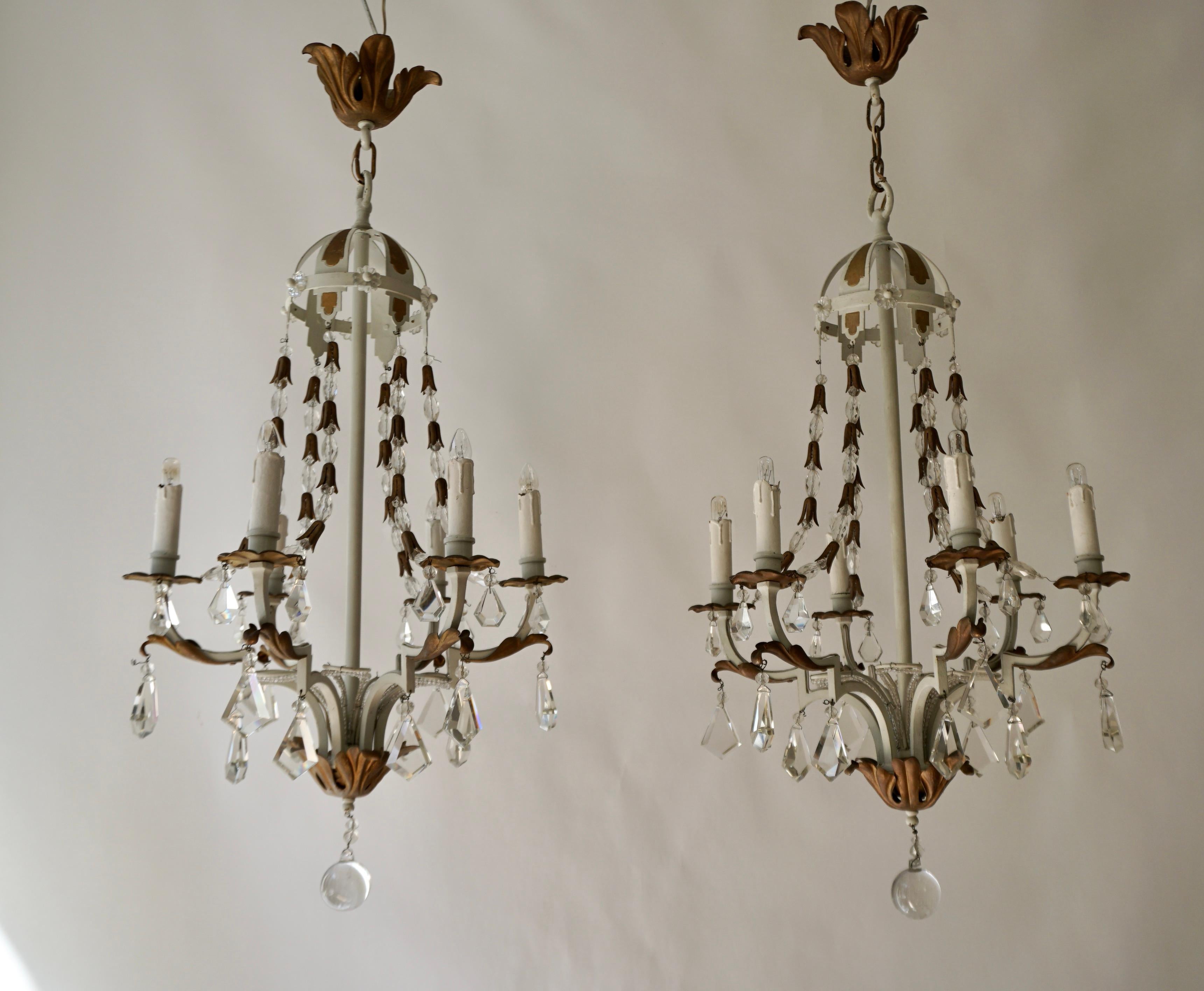 Two 6-light white/gold metal chandeliers decorated with brass acanthus leaves and hung with crystal icicles.
France ,20th century.

Diameter 18
