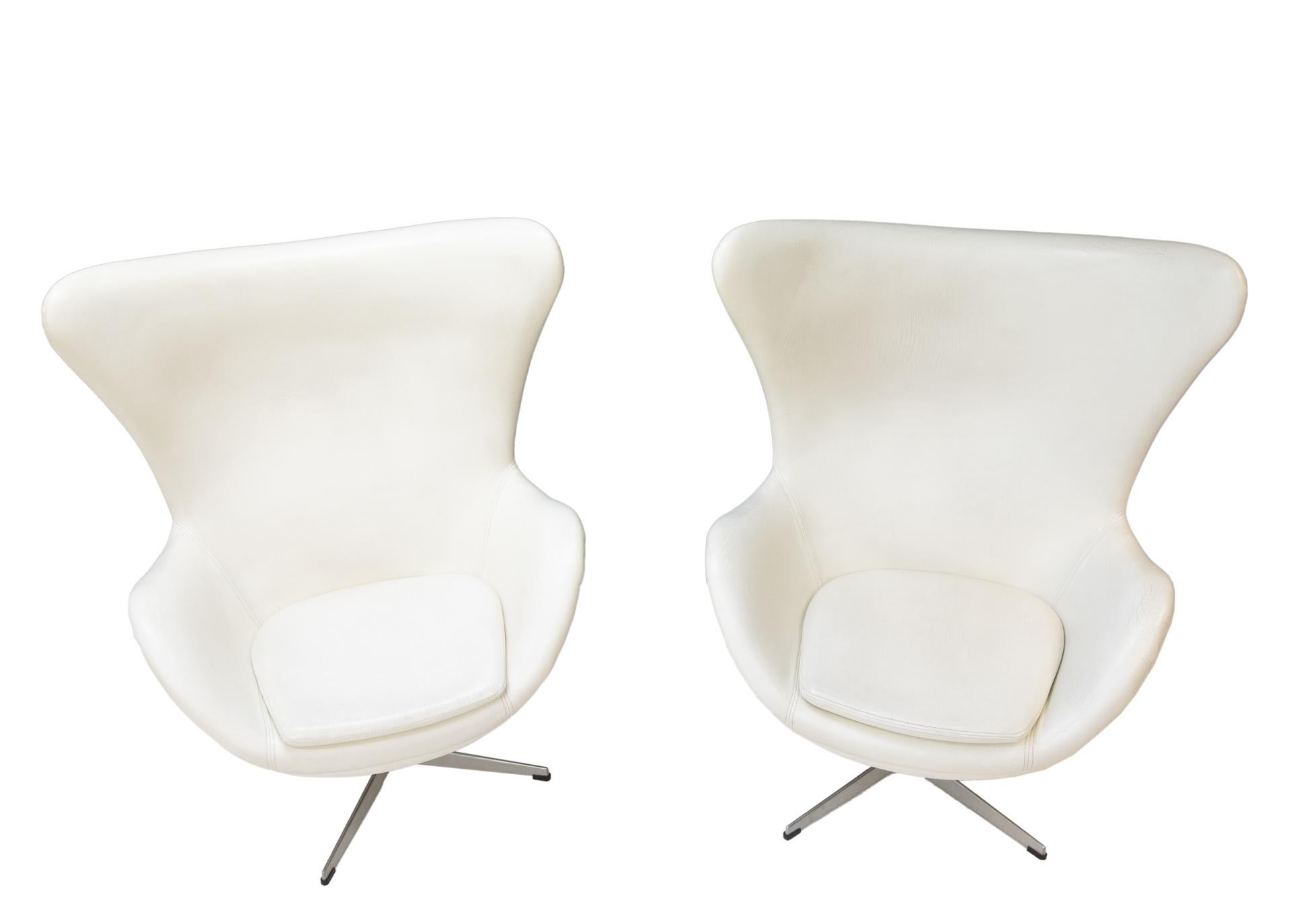Two white leather egg chairs with matching foot stool. I am afraid no Fritz Hansen signature. So these
are replicas. But these are very nice ones. From the 1970s good made chairs, complete with swivel Stand and with just the right amount off wear.