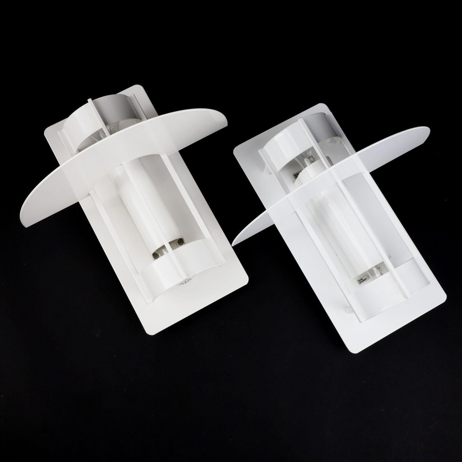 Experience timeless elegance with four vintage wall lights crafted by the renowned designer Joachim Lepper for Louis Poulsen. These modern wall lamps illuminate spaces with casting a gentle glow both upwards and downwards. The sophisticated design