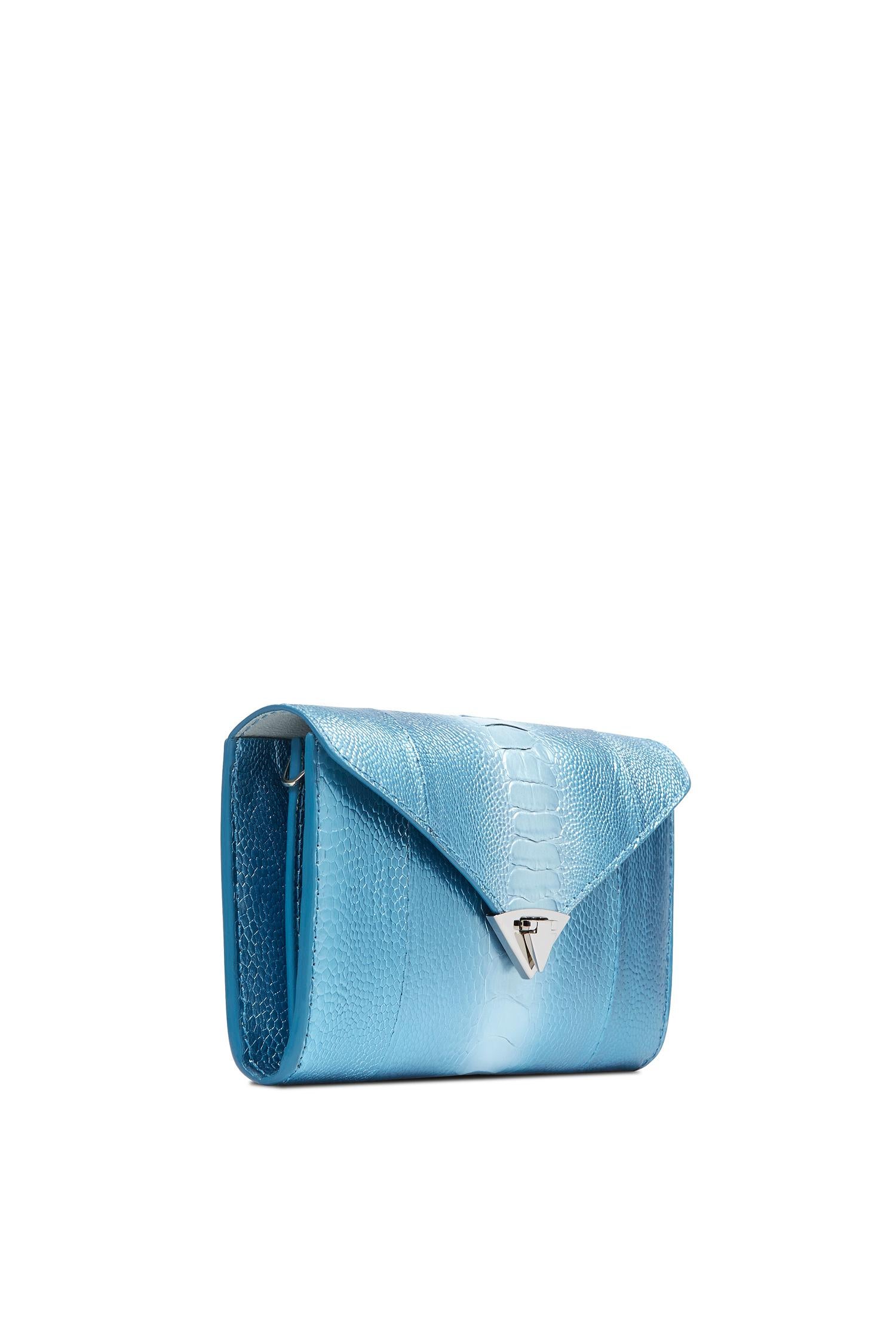 The Alex Wallet Blue Ice Ostrich Leg Silver Hardware is designed with a detachable silver cross-body chain, interior credit card slots and a pinecone pull zip pocket. It features our signature spear-lock closure and Thayer blue leather
