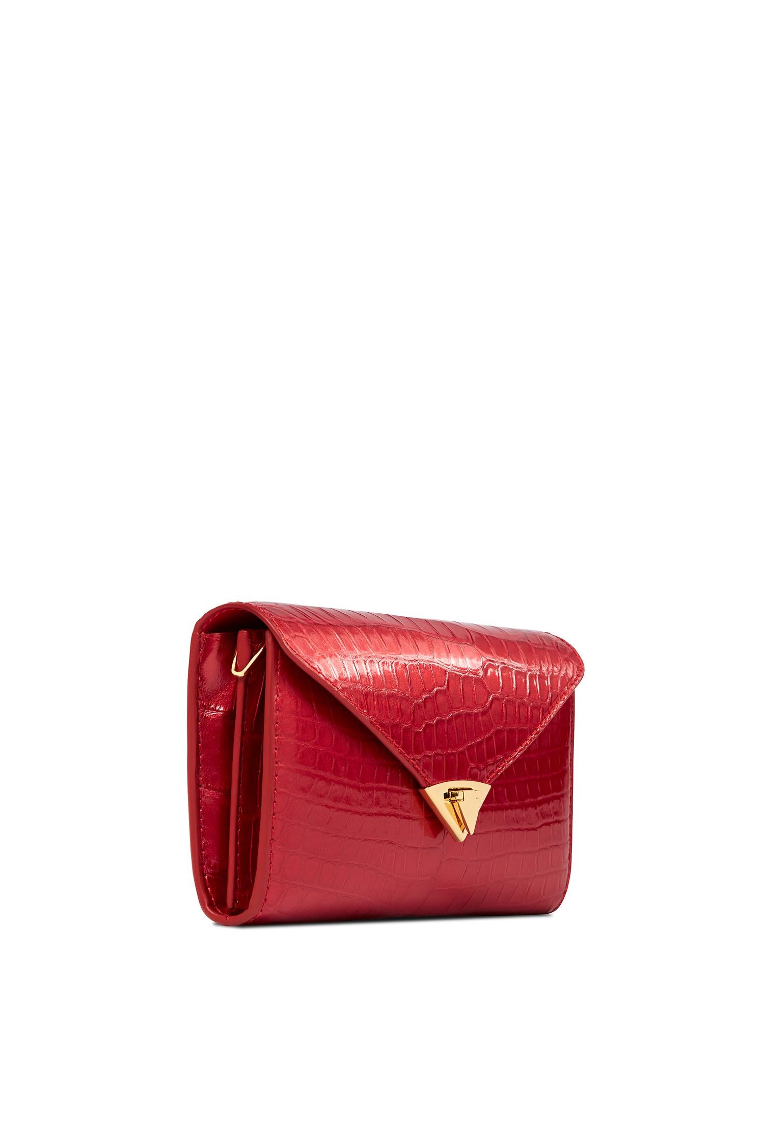 The Alex Wallet Candy Apple Red Glossy Alligator Gold Hardware is designed with a detachable gold cross-body chain, interior credit card slots and a pinecone pull zip pocket. It features our signature spear-lock closure and Thayer blue leather