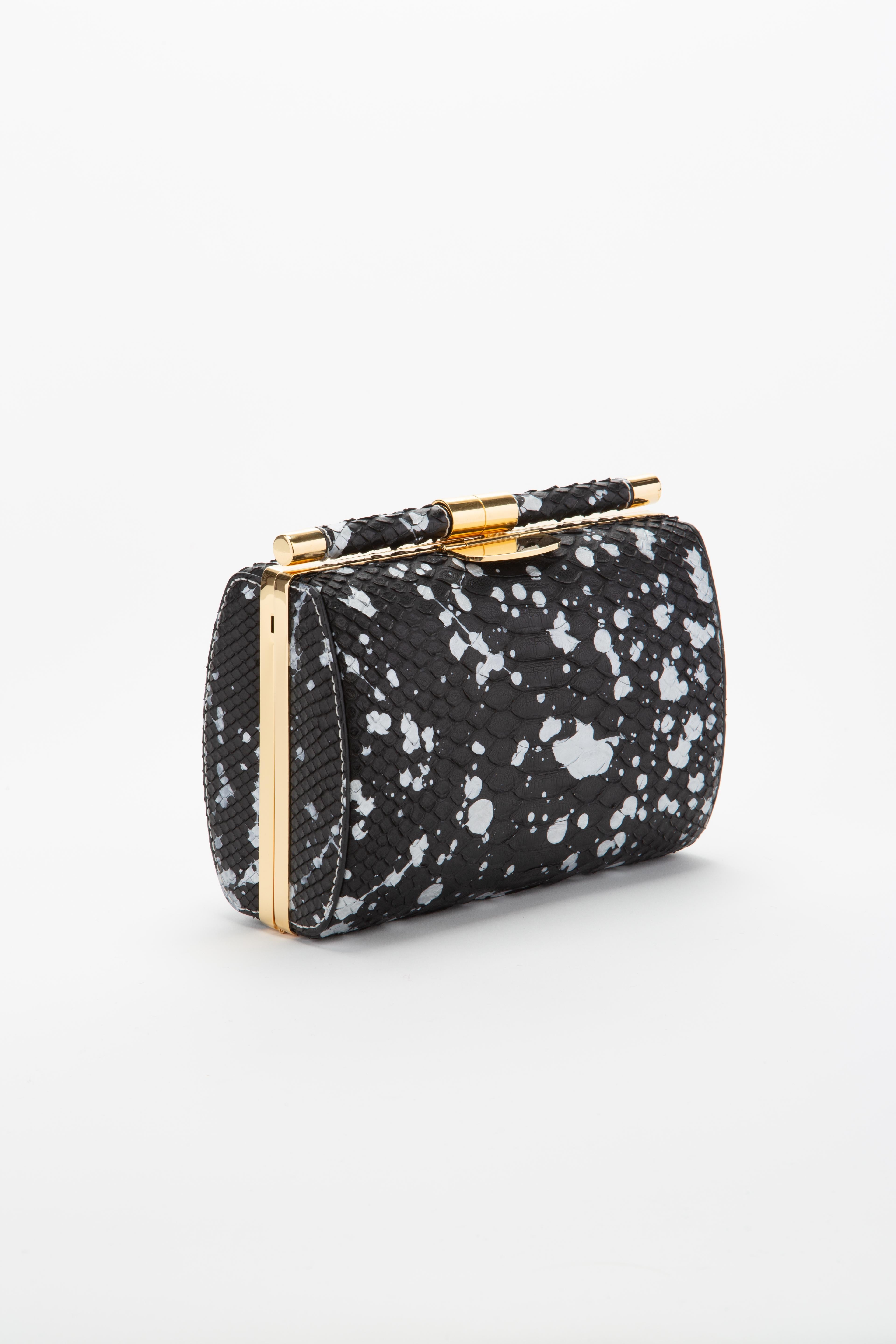 The Anjuli clutch is a structured oval clutch, with an optional cross-body chain, and interior pocket. It features our signature slide-lock closure and Thayer blue satin lining. 

Size: Medium
Hardware: Gold
Interior/Lining: Satin
Dimensions: 7.5” L
