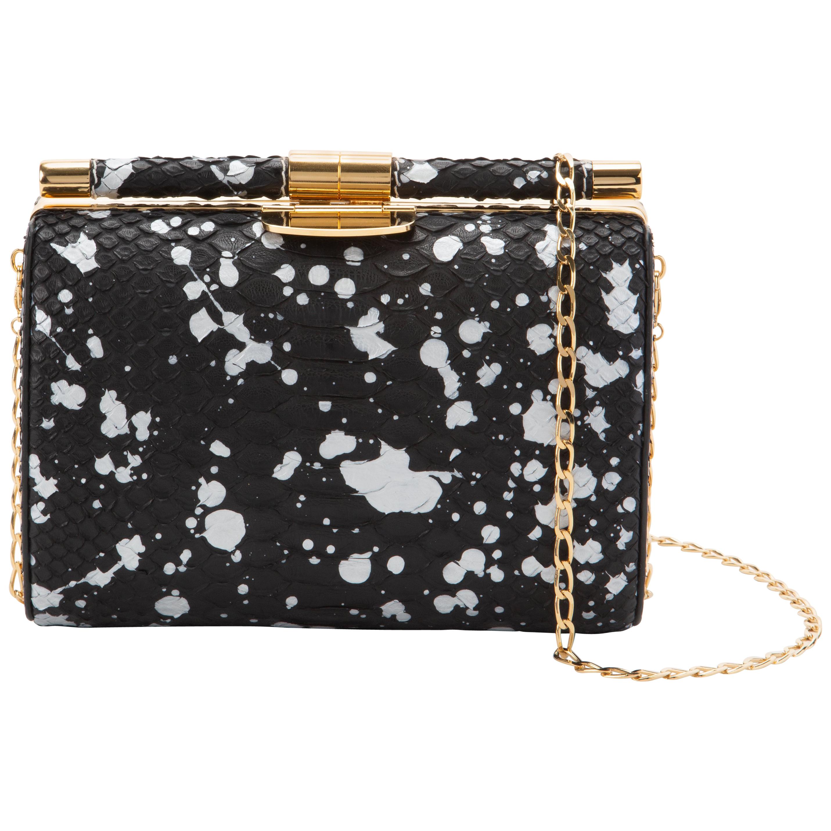 The Anjuli clutch is a structured oval clutch, with an optional gold cross-body chain, and interior pocket. It features our signature slide-lock closure and Thayer blue satin lining. 

**Please note that we are unable to ship Python anywhere in the
