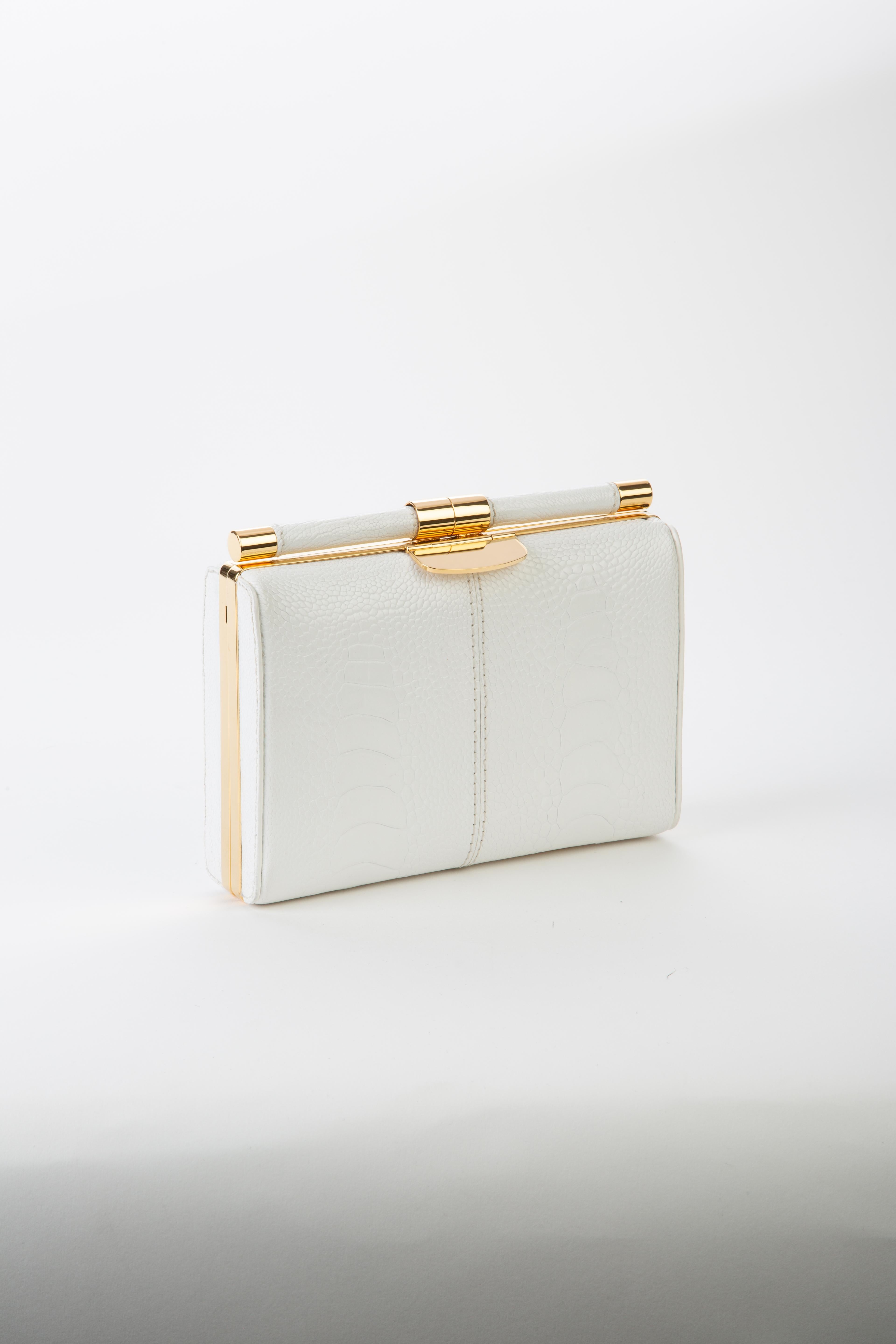 The Jamie Clutch is a structured square clutch with an optional cross-body chain and interior pocket. It features our slide-lock closure and signature Thayer blue satin lining. 

Size: Small
Hardware: Gold
Interior/Lining: Satin
Dimensions: 7.5” W x