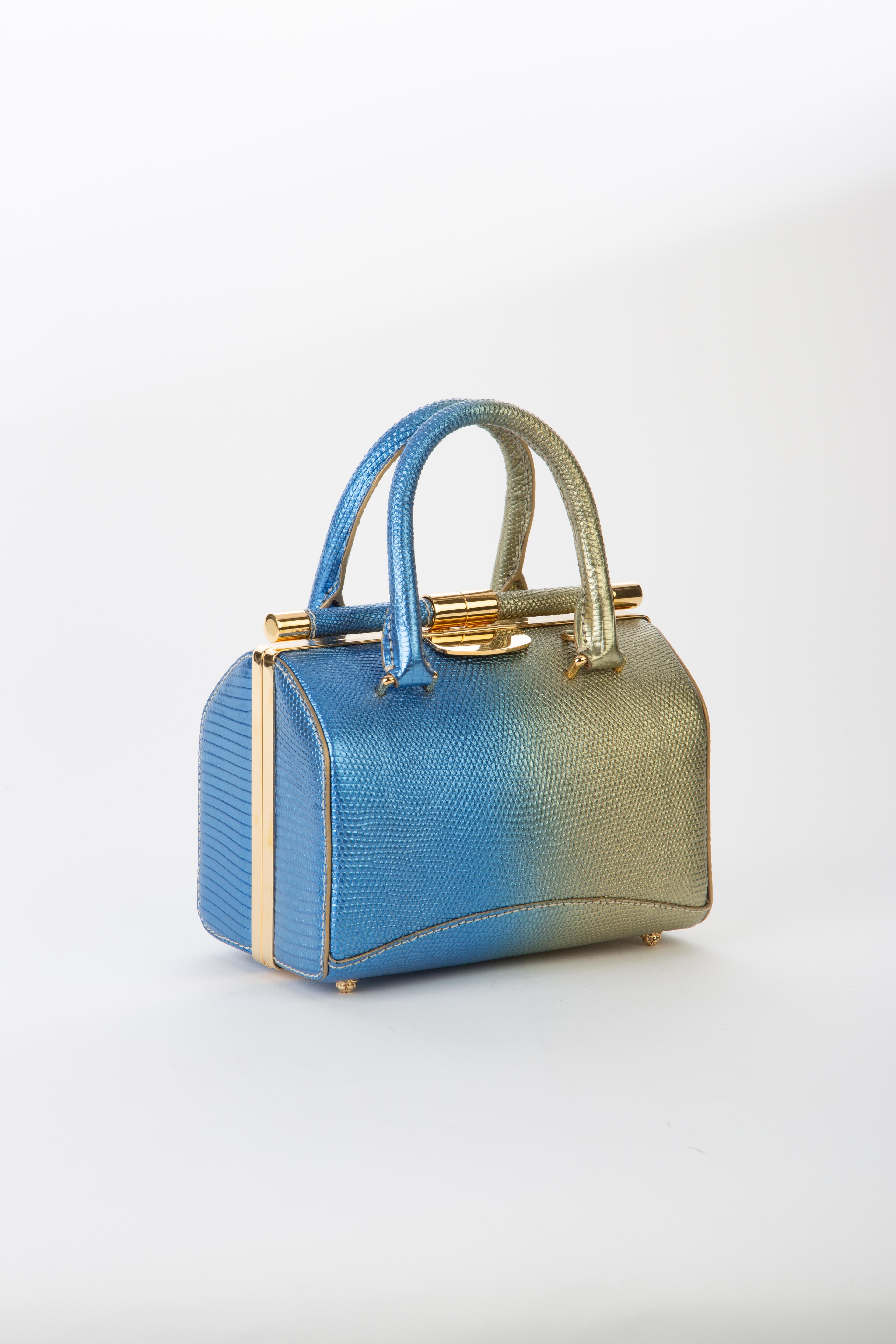 The Jamie Doctor is a double handle structured bag. It features our slide-lock closure, pinecone feet, interior pocket and our signature Thayer blue suede lining. 

Size: Small
Hardware: Gold
Interior/Lining: Suede
Dimensions: 7.5” W x 5.0” H x 4.0”