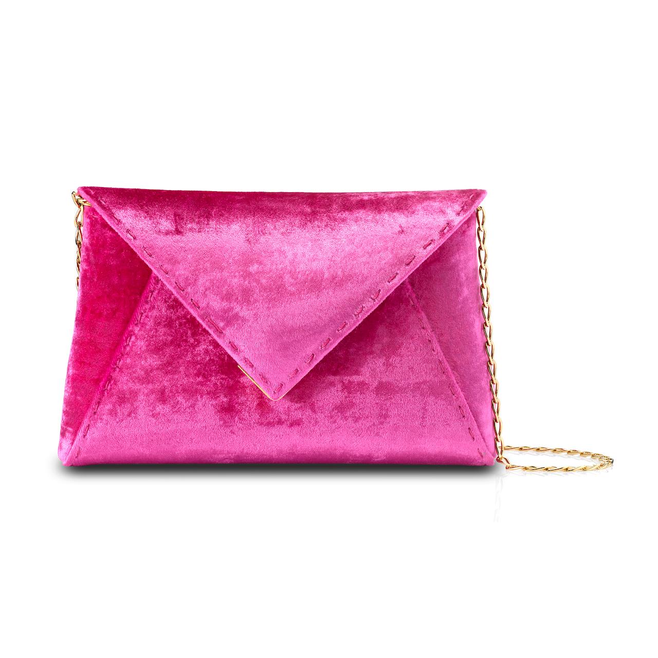The Lee Pouchet Small Clutch is featured in our Fuchsia crushed velvet with gold hardware. The envelope-shaped clutch is designed with a triangular front flap and a magnetic snap closure. The exterior detailing is entirely hand-stitched. The Lee