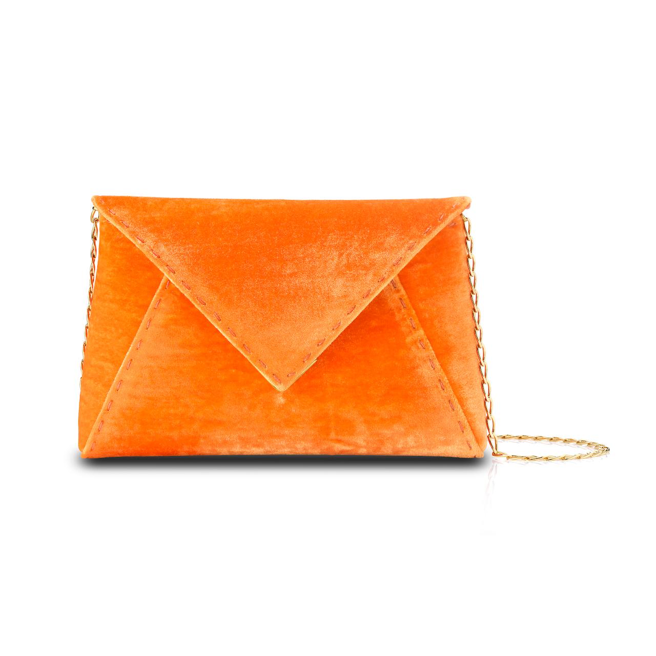 The Lee Pouchet Small Clutch is featured in our Tiger Orange crushed velvet with gold hardware. The envelope-shaped clutch is designed with a triangular front flap and a magnetic snap closure. The exterior detailing is entirely hand-stitched. The