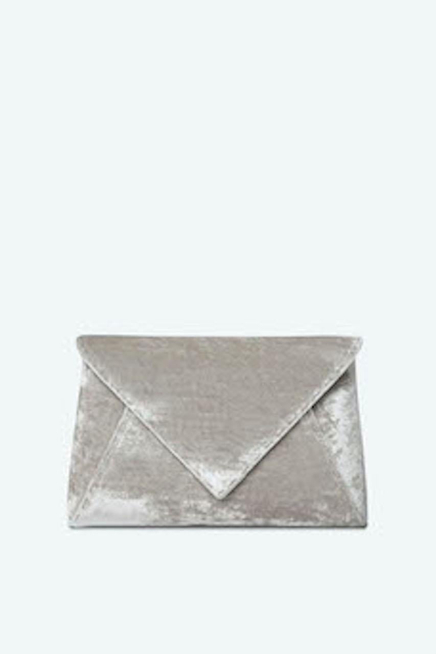 The Lee Pouchet Small is featured in our Platinum crushed velvet with silver hardware. The envelope-shaped clutch is designed with a triangular front flap and a magnetic snap closure. The Lee fits the large iPhone, has a hidden exterior pocket, an