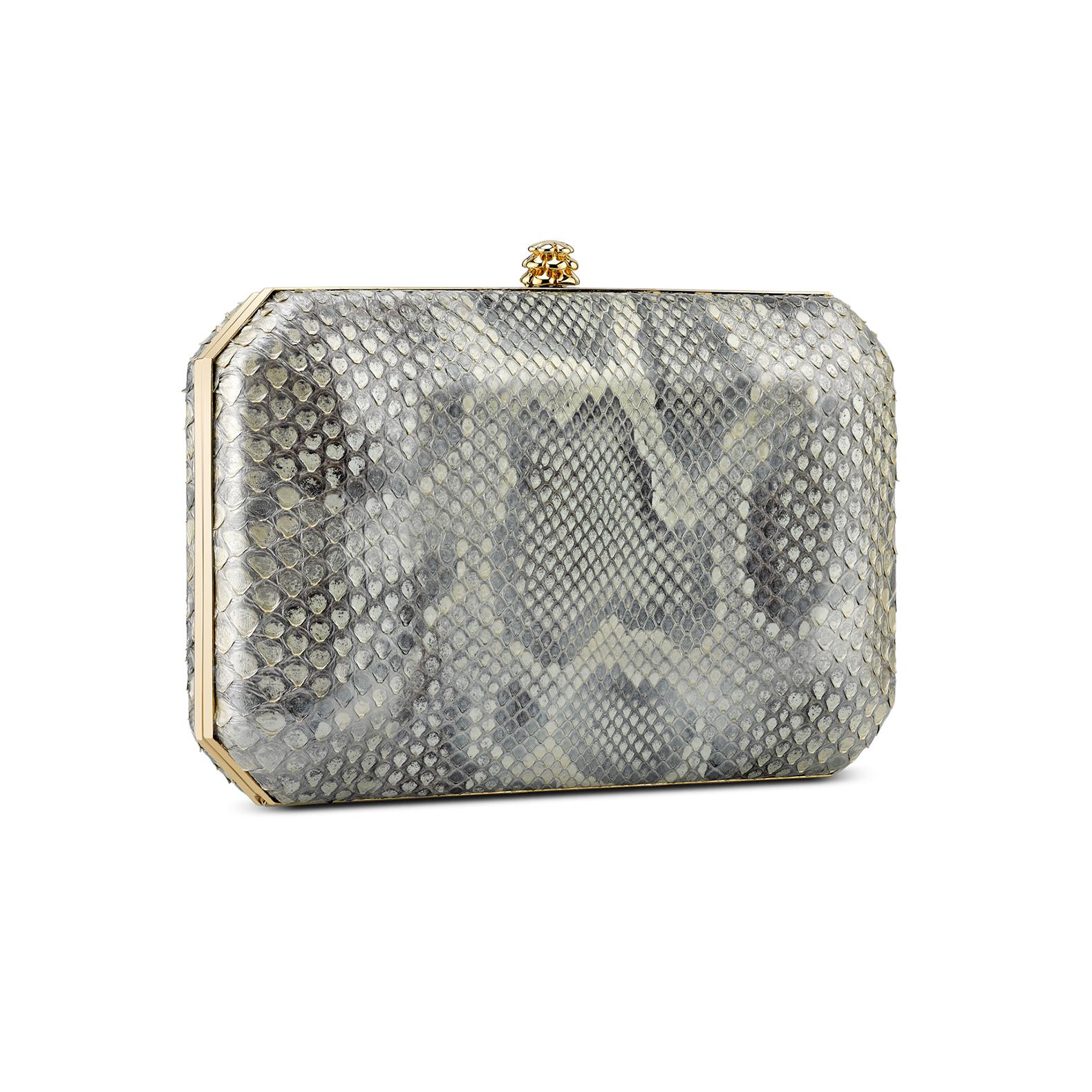 The Lily Clutch in Golden Dust Glossy Python Gold Hardware is a hard-framed rectangular clutch designed with interior pockets and an optional cross-body chain. It fits the iPhone 8+ and features our signature pinecone closure and Thayer Blue