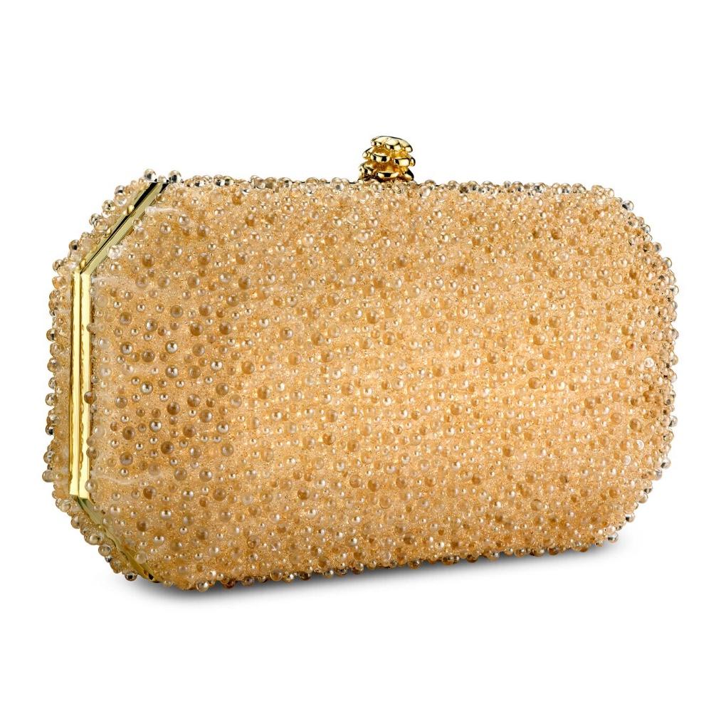 The Perry Clutch in Gold Bubble Swarovski Crystal is a hard-framed clutch designed with interior pockets and an optional gold cross-body chain. Its elegant emerald shape is inspired by Tyler’s own engagement ring and named after her father, Perry