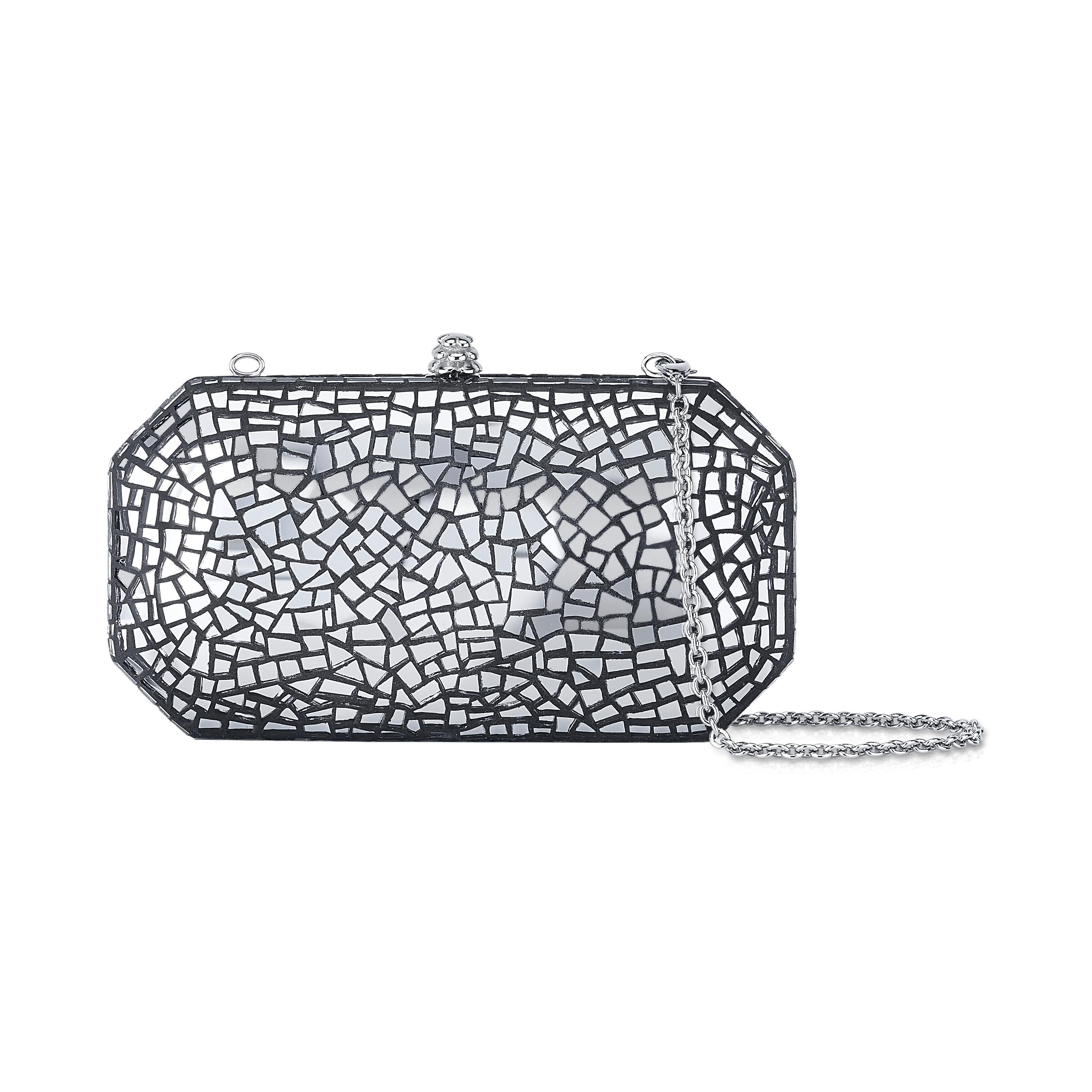 The Perry in Emperor's Jewel Mosaic Tile is a hard-framed clutch designed with interior pockets and an optional silver cross-body chain. Its elegant emerald shape is inspired by Tyler’s own engagement ring and named after her father, Perry Ellis. It