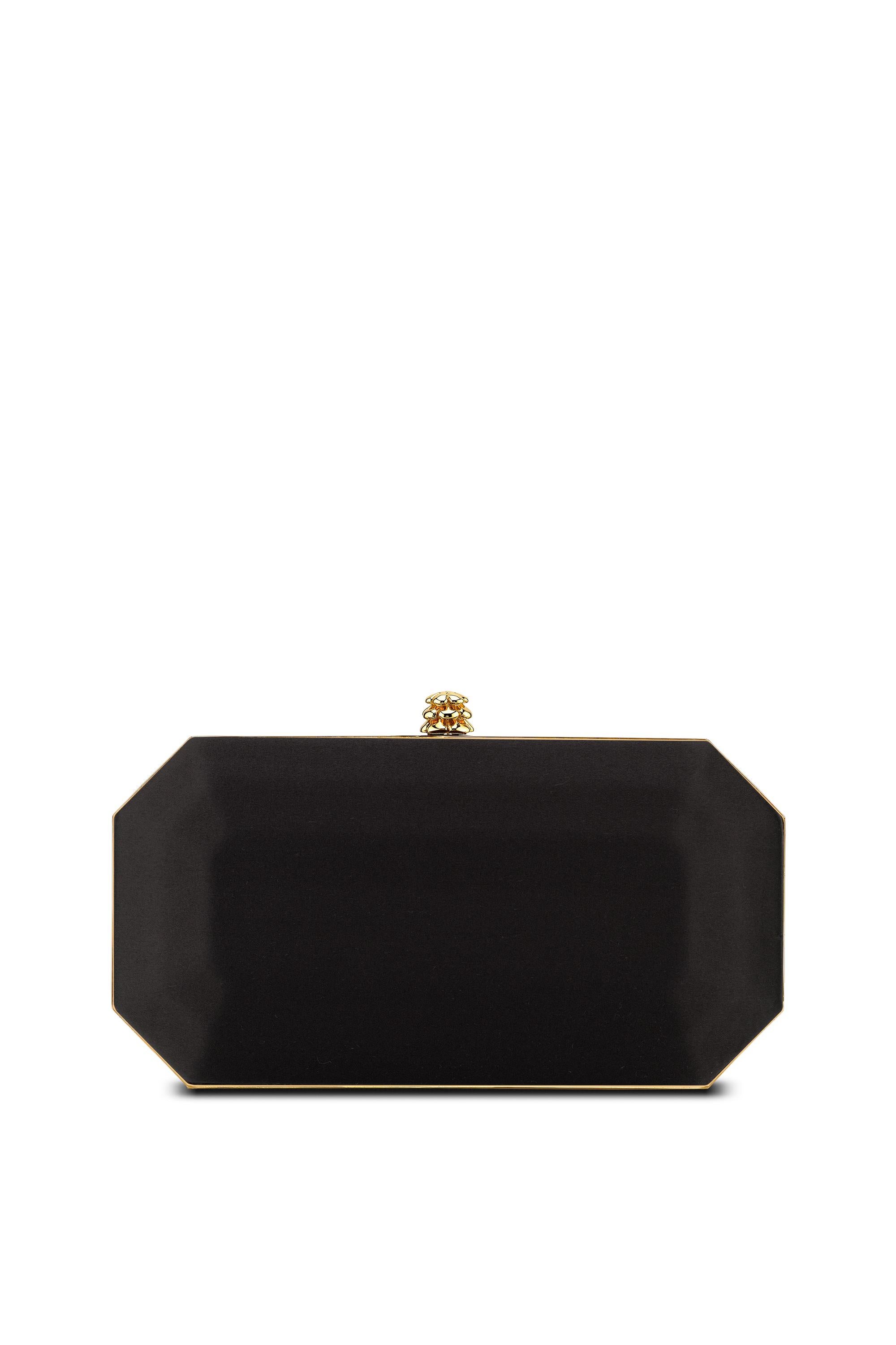 The Perry Small is featured in our Black Diamond satin with gold hardware. The Perry is a hard-framed clutch designed with interior pockets and an optional gold cross-body chain. It's elegant emerald shape is inspired by Tyler's own engagement ring