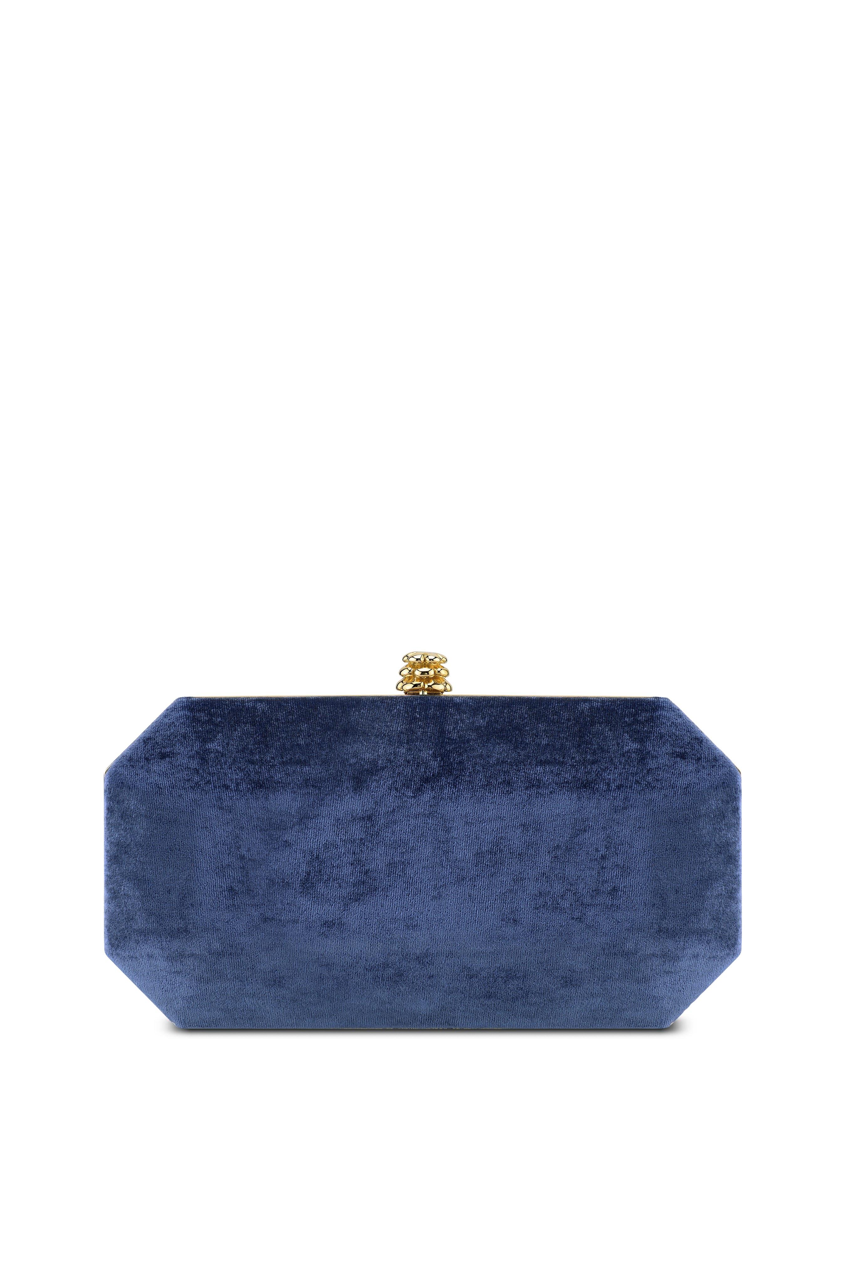 The Perry Small is featured in our Navy Blue crushed velvet with gold hardware. The Perry is a hard-framed clutch designed with interior pockets and an optional gold cross-body chain. It's elegant emerald shape is inspired by Tyler's own engagement