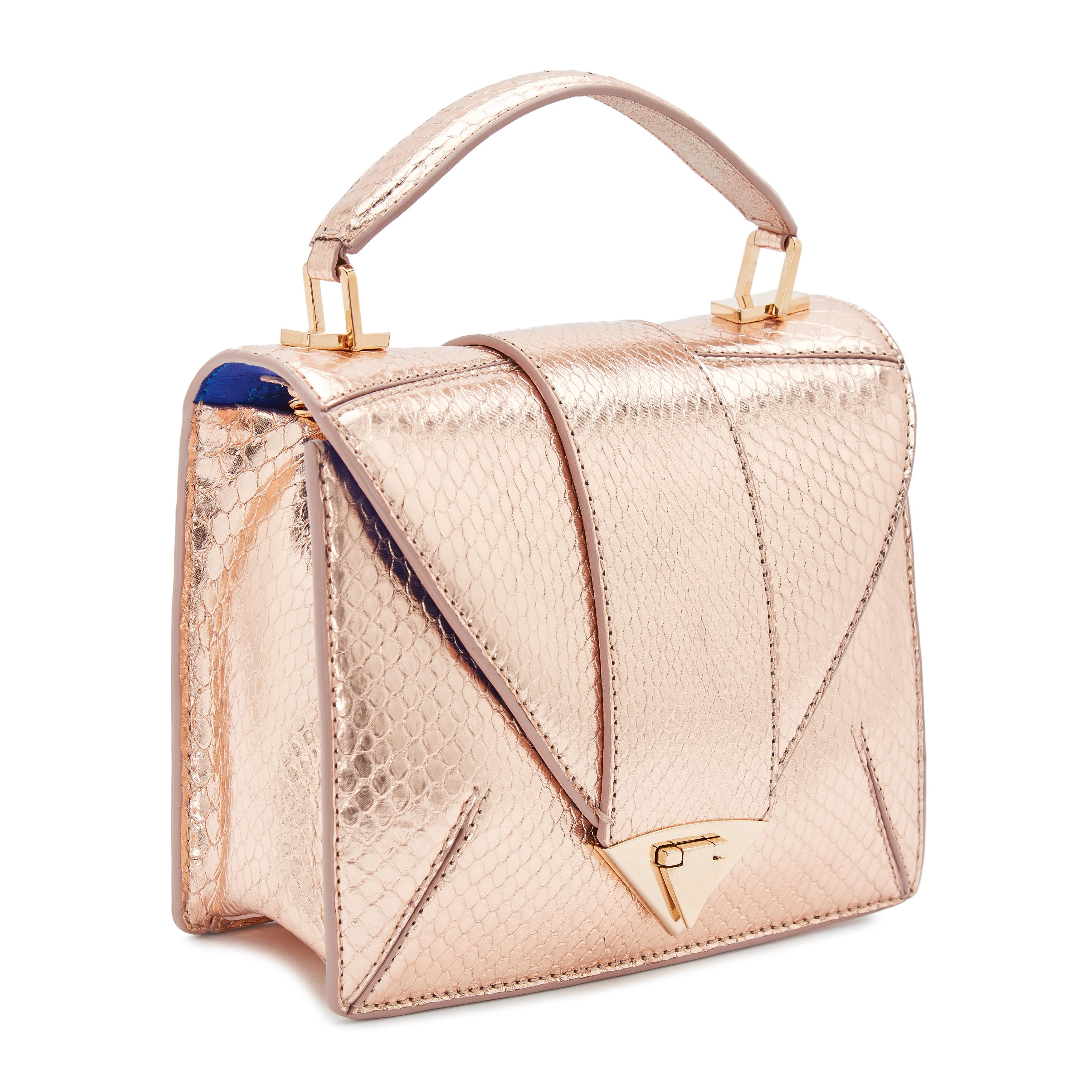 The Rita Small Rose Gold Python Rose Gold Hardware is a semi-structured handbag with a triangular front-flap and our custom spear-lock closure. It is designed with a flexible top handle and an optional chain with Rose Gold Python accent.  It has a
