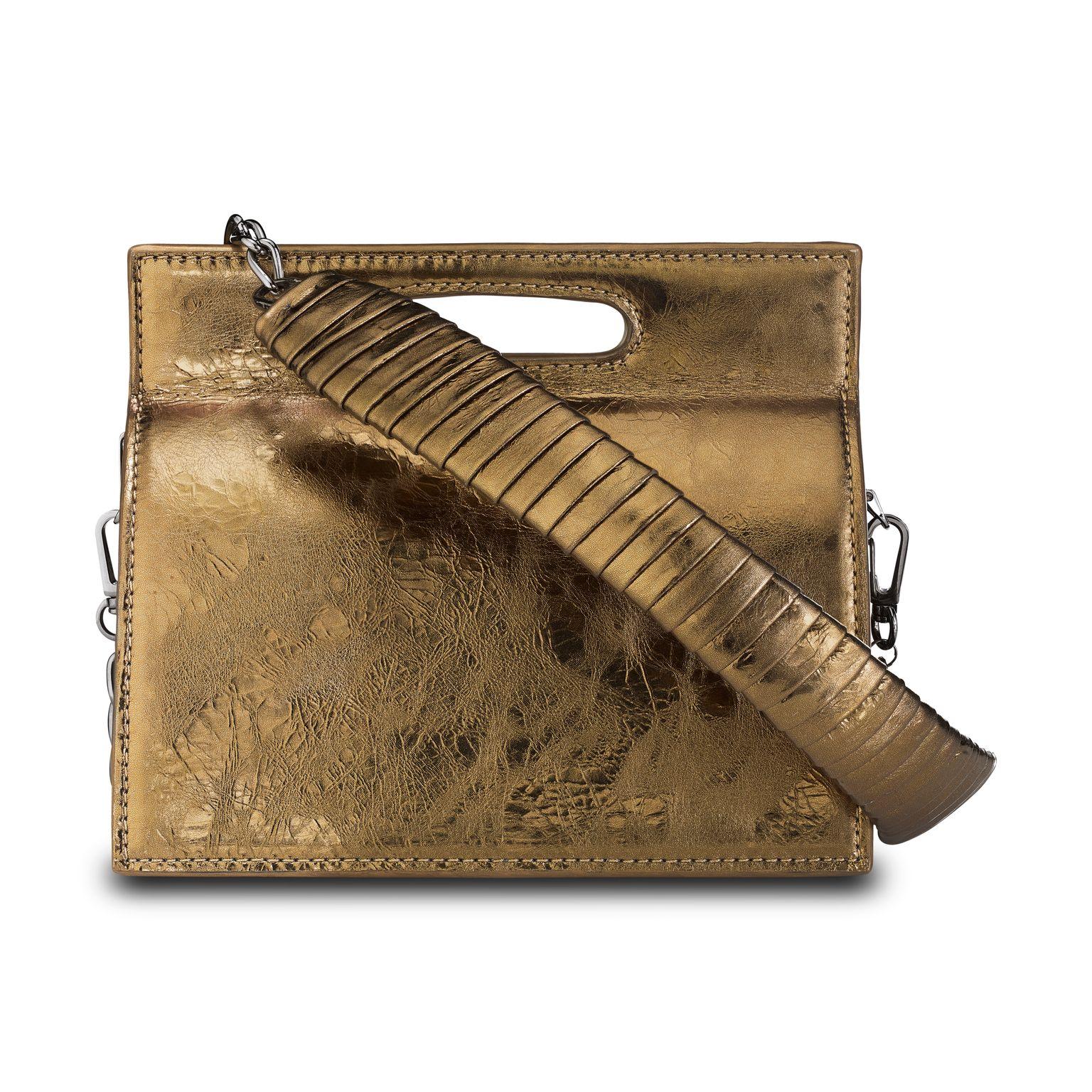 The Stella Handbag Petite is featured in Bronze Antiqued Leather with gunmetal hardware. The structured tri-compartment handbag has a magnetic closure and an optional cross-body gunmetal chain with a matching leather wrapped accent. It fits the