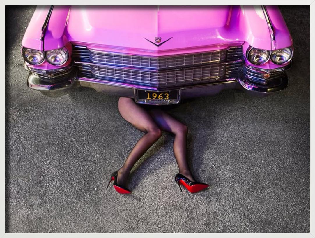Cadillac Legs - Frau in Heels unter rosa Auto liegend, Kunstfotografie 2025 – Photograph von Tyler Shields