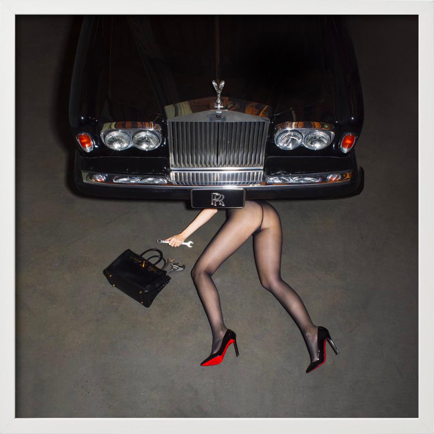 A woman with black Louboutin heels, only black tights, and a black Birkin bag lying under a Rolls Royce car was photographed by Tyler Shields in 2022. 

All prints are limited edition. Available in multiple sizes. High-end framing on request.

All