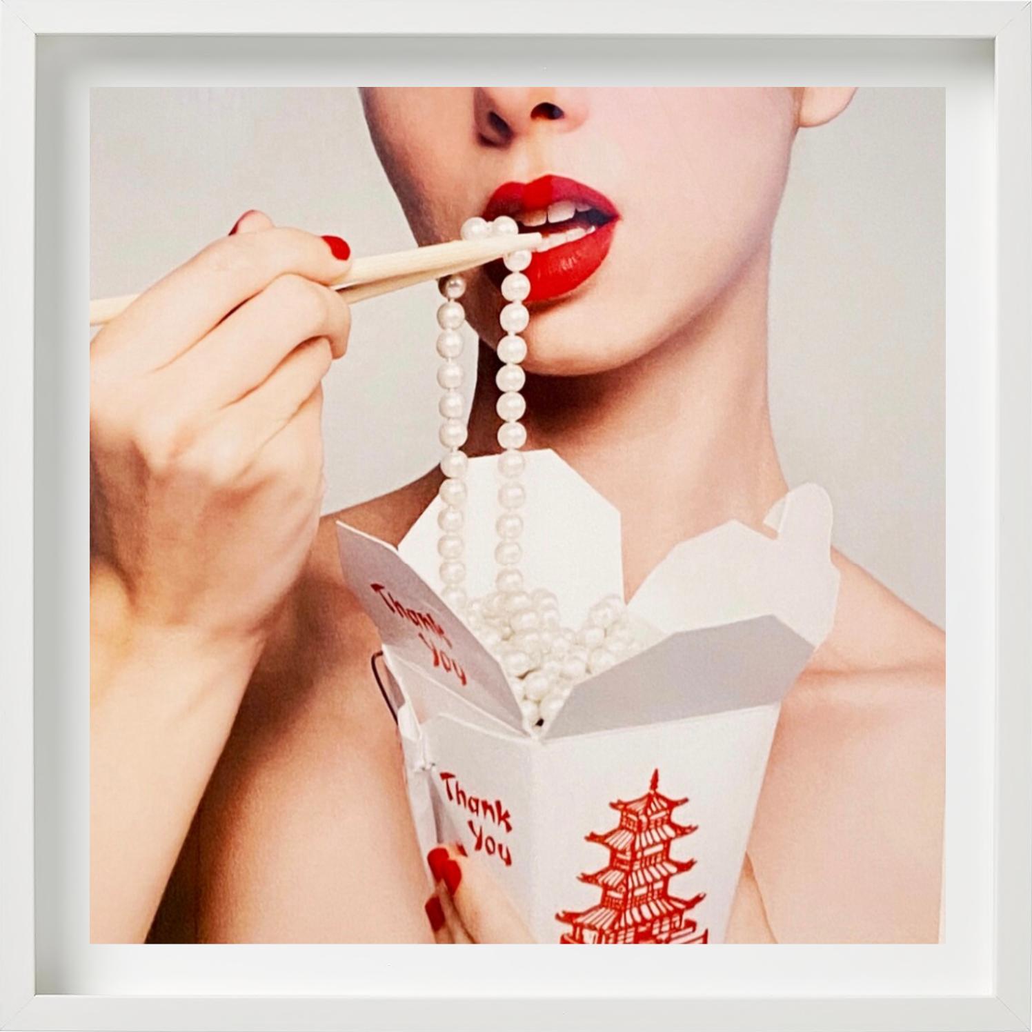 Eine Frau mit roten Lippen und Nägeln, die chinesisches Essen zu sich nimmt und weiße Perlen trägt, fotografiert von Tyler Shields im Jahr 2021. 

Alle Drucke sind in limitierter Auflage erhältlich. Erhältlich in mehreren Größen. Hochwertige
